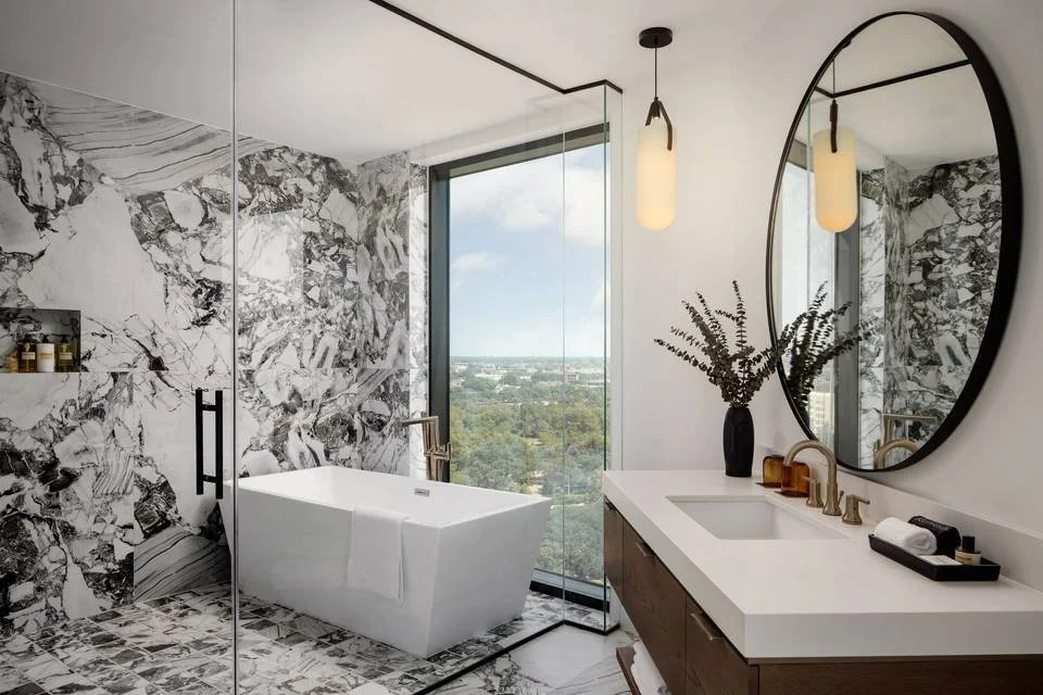 A modern, luxury walk-in bathroom featuring waterproof porcelain shower walls with continuous veining.
