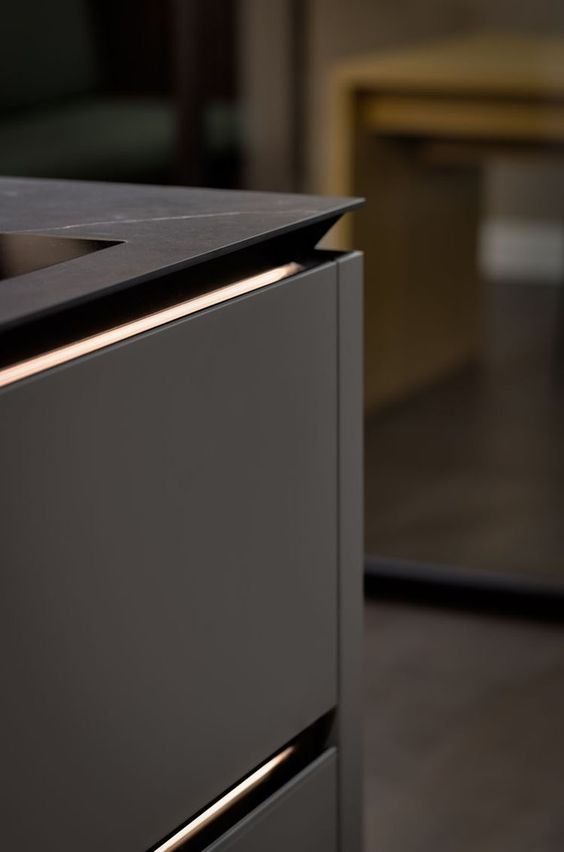 Architectural close-up of a large-format porcelain countertop featuring a fabricated shark nose edge profile, showcasing the reverse bevel undercut and shadow line.