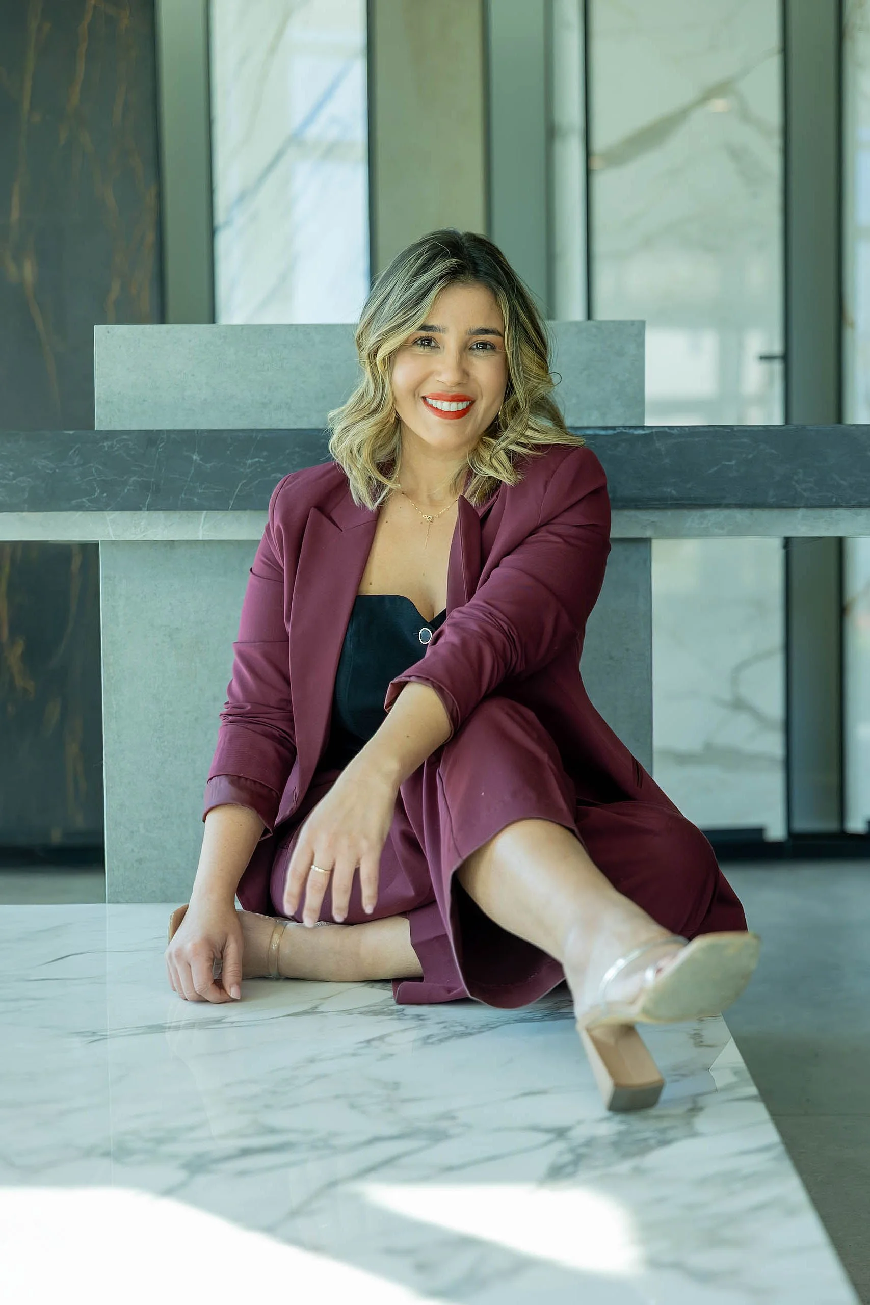 Luxury surface expert Lais Luz reviewing a custom modern outdoor kitchen layout featuring weatherproof Italian cabinets on a Longboat Key patio.