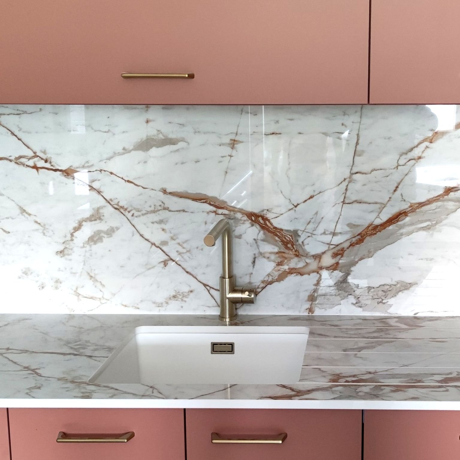 Contemporary Kitchen featuring Dekton Awake countertops with eased edges, a matching backsplash, and vibrant dusty rose cabinetry.