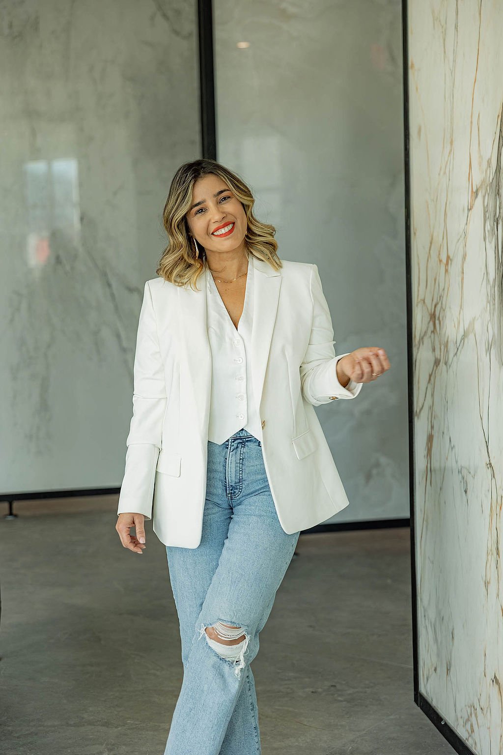 Lais Luz holding and comparing different marble look porcelain countertop samples to find the perfect match for a kitchen remodel.