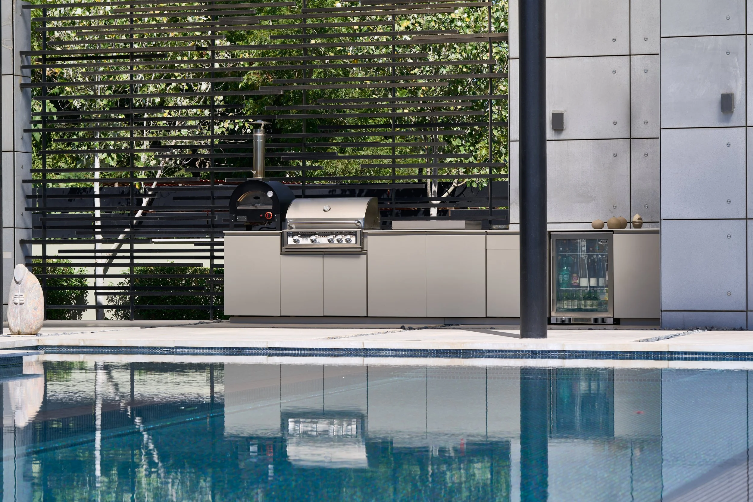 A high-end waterfront estate featuring weather-proof Capo Cuoco Unica series outdoor cabinets paired beautifully with seamless luxury Dekton surfaces.