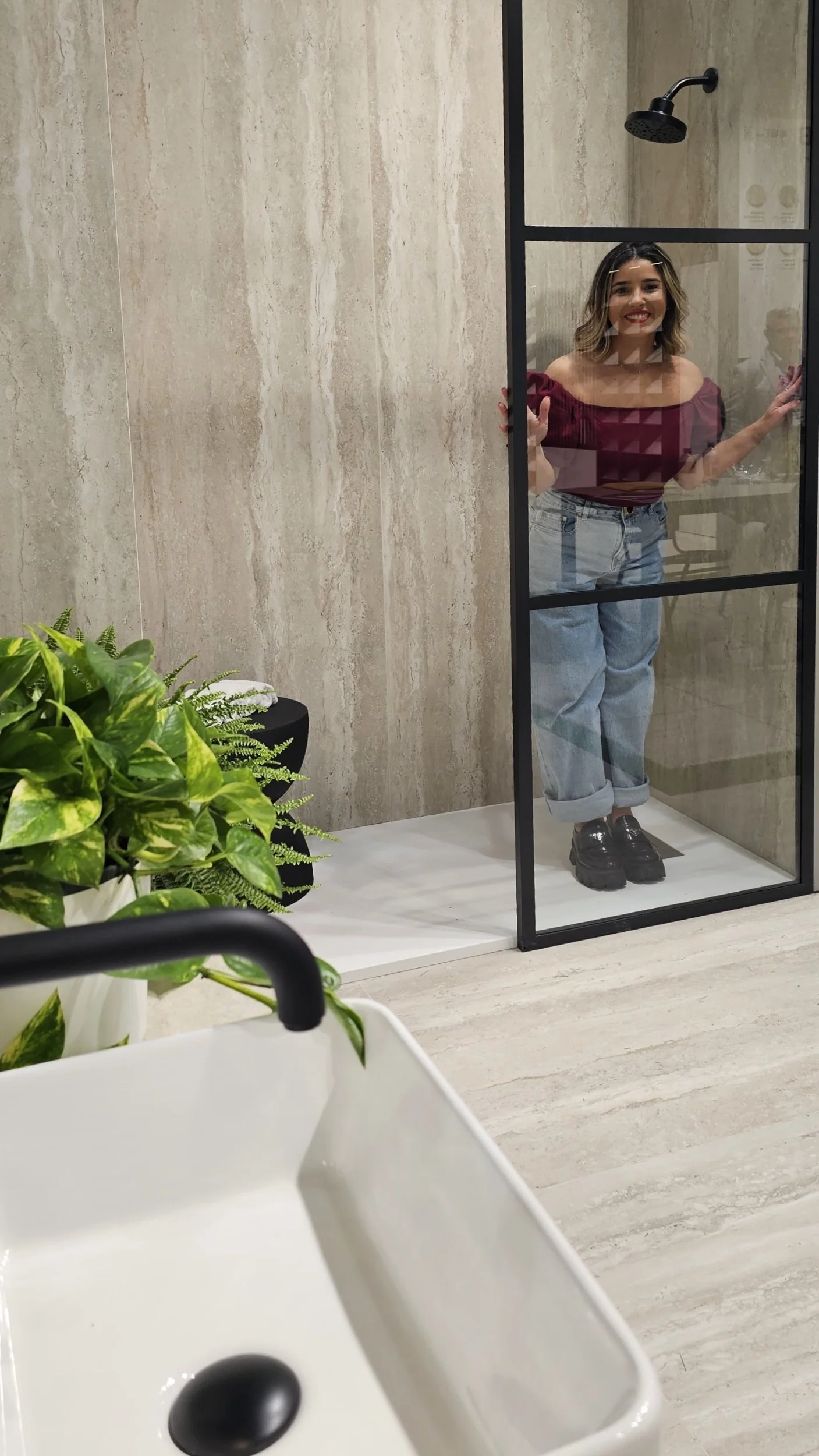 Global mineral surface expert Lais Luz reviewing a custom-engineered, large-format porcelain slab shower wall installation in Sarasota, Florida.