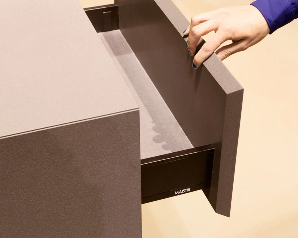 A minimalist kitchen island featuring large-format porcelain cabinet cladding and integrated shark nose finger pulls, inspired by high-end European design.