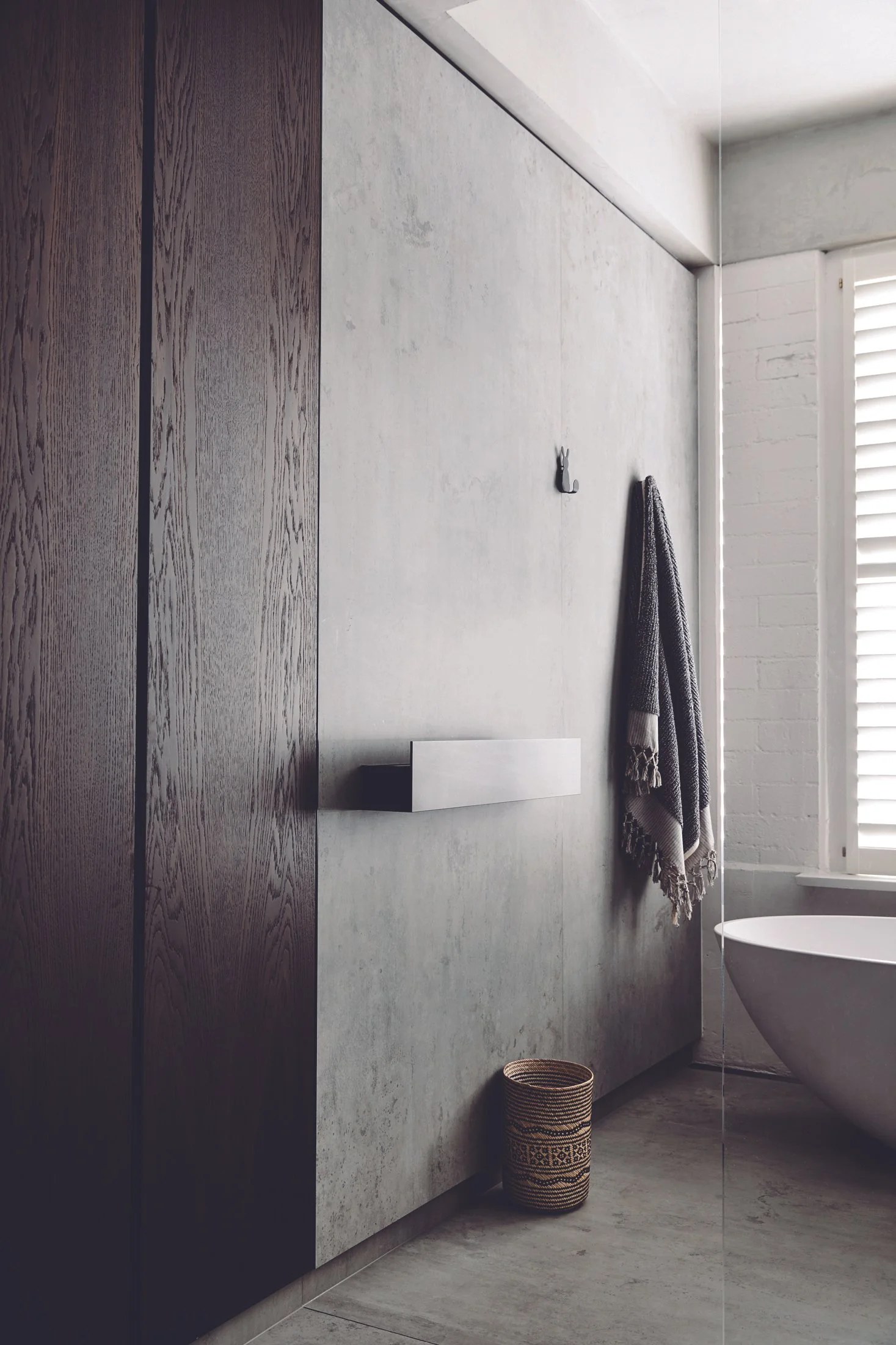 A luxury grout-free shower enclosure lined with large-format porcelain slabs to prevent moisture absorption and mold growth in flood-prone coastal Florida homes.