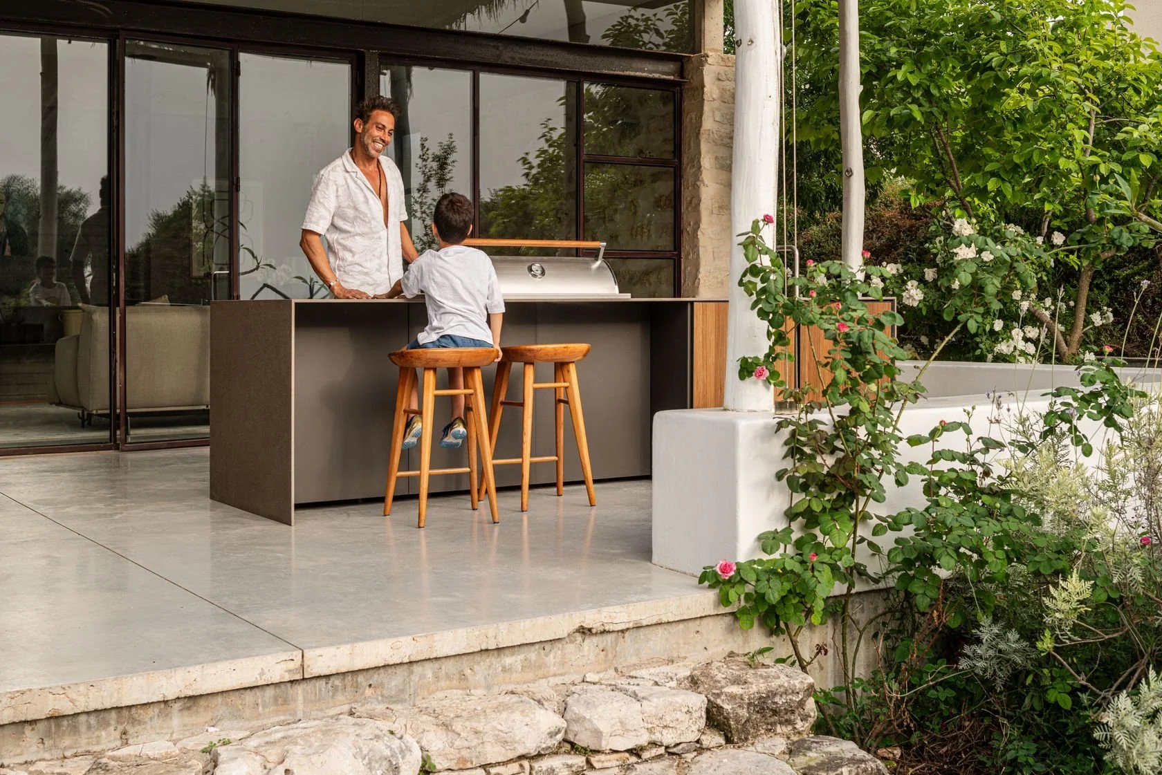 A contemporary outdoor kitchen island featuring premium weatherproof cabinets, integrated bar stool seating, and a seamless stone surface layout on a Longboat Key pool deck.