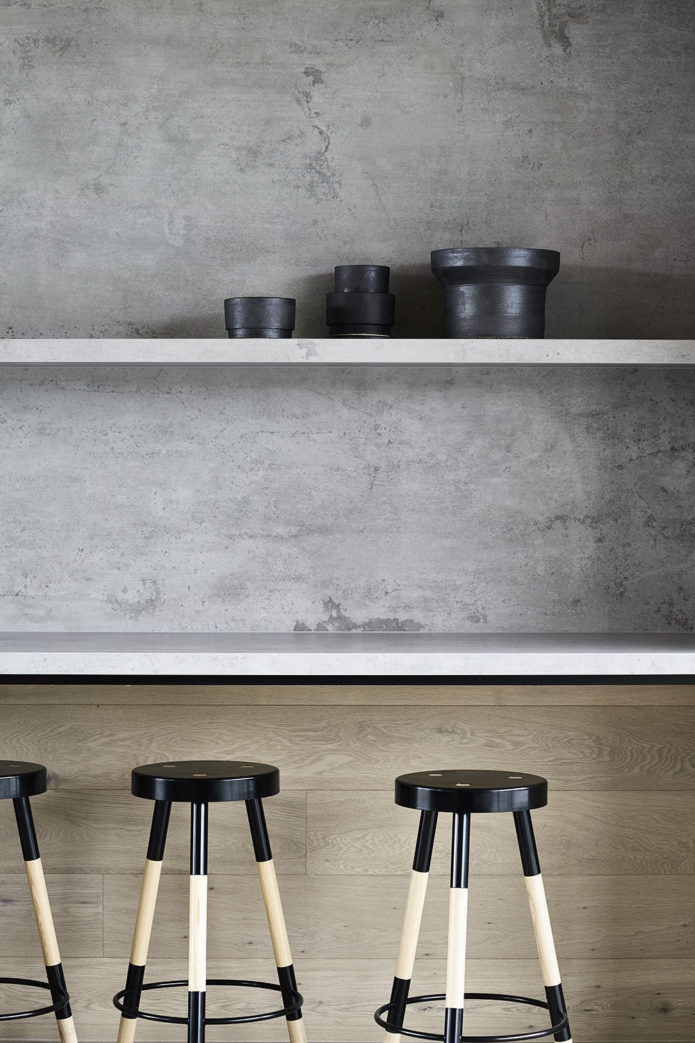 A high-end bathroom vanity wall featuring full-height porcelain cladding and a matching stone shelf detailed with a flawless 45-degree mitered edge profile.