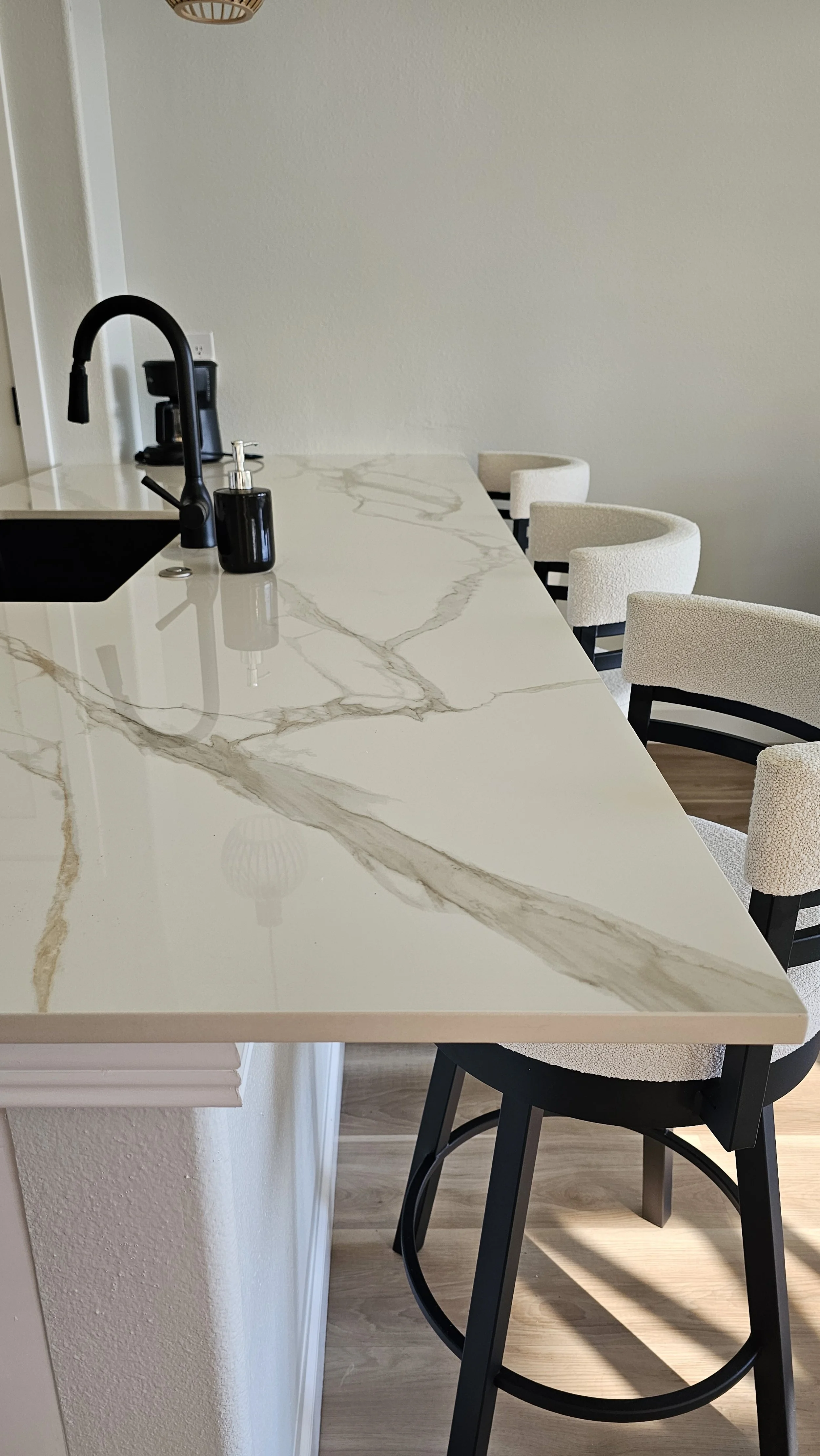 Black accents on the sink, faucet, and cabinet pulls brought a modern sophistication that perfectly complements the classic Calacatta Oro.