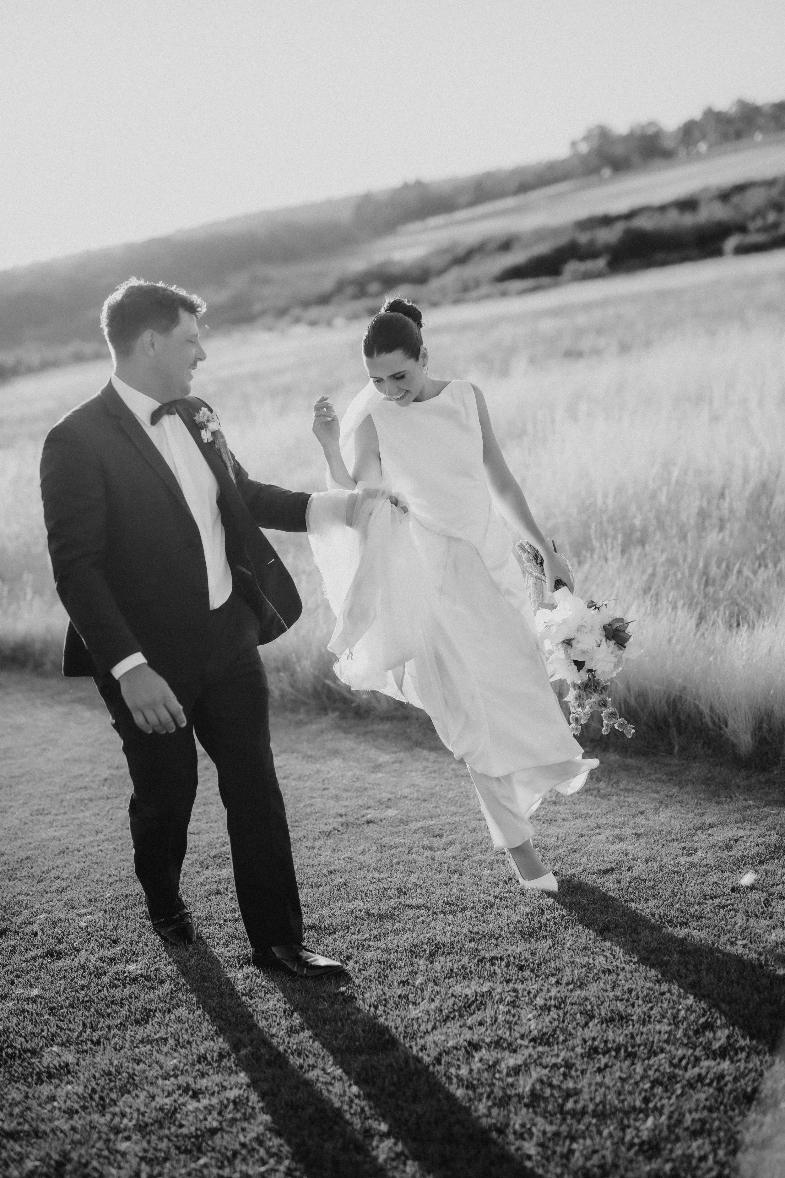 Bride and groom for far a walk in the paddock at sunset at the tiller farm