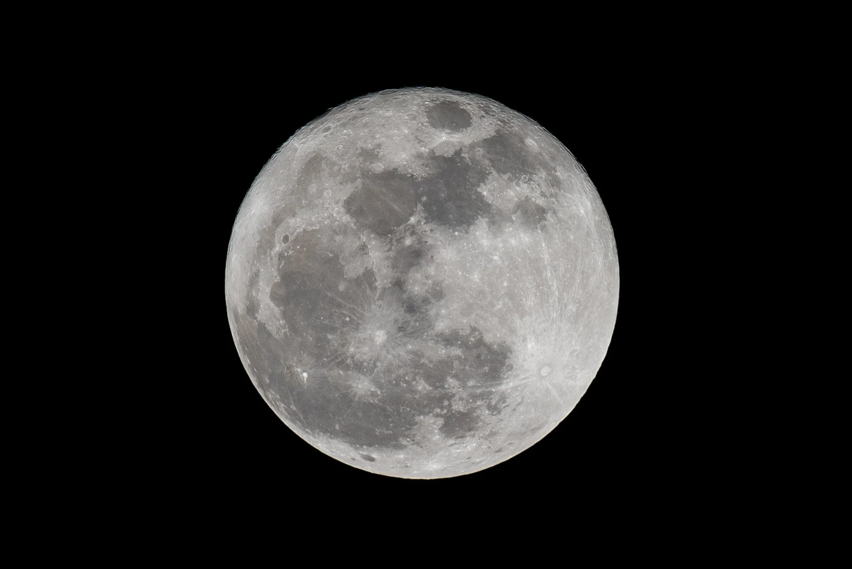 Full moon against a black night sky. Photo by Brock Byers