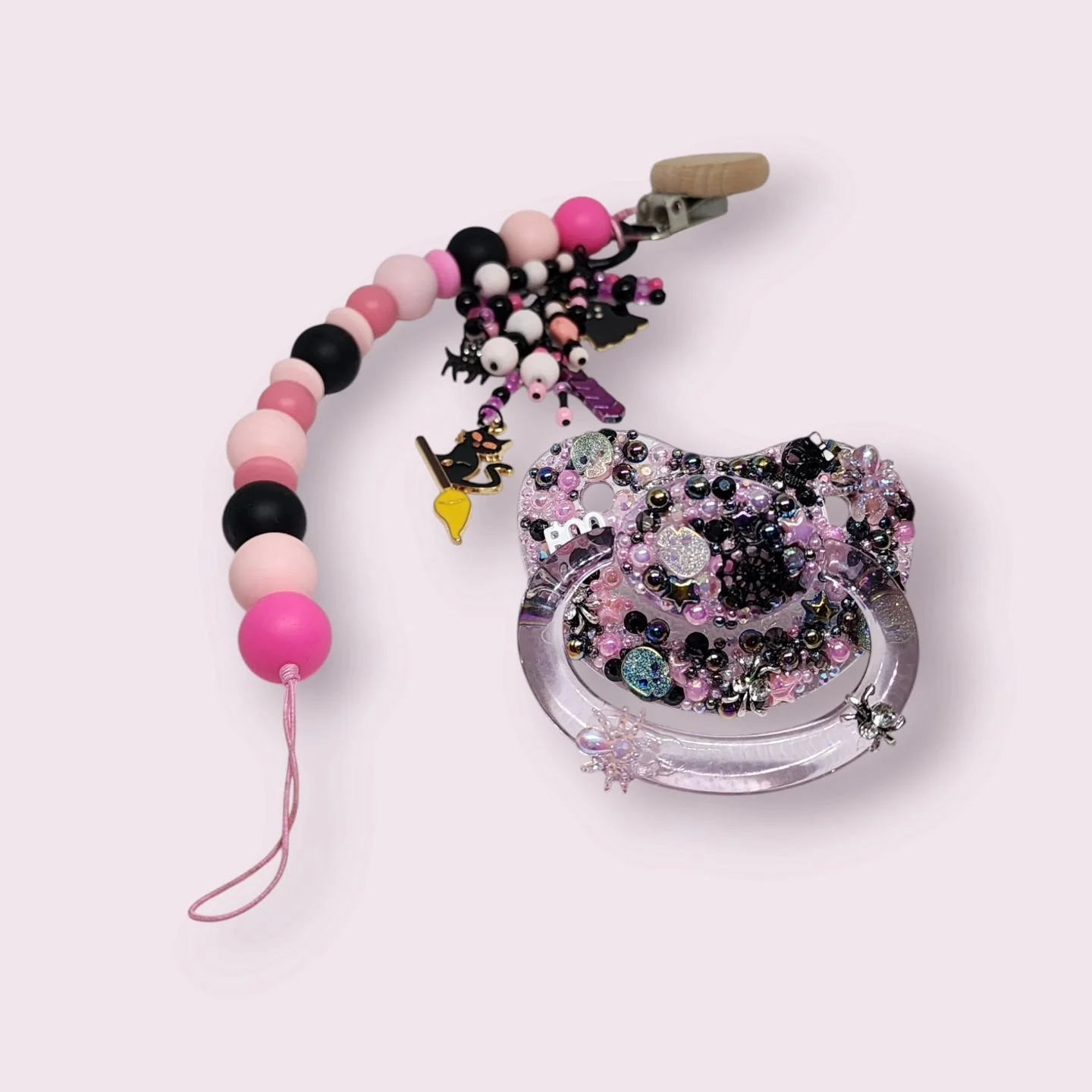 🖤👻 New in our Halloween collection! Introducing a spook-tacular pink and black pacifier with a matching paci clip. Perfect for adding a touch of Halloween charm, whether it&rsquo;s trick-or-treating or just keeping cozy this season. 🎃🌙 Head to ou