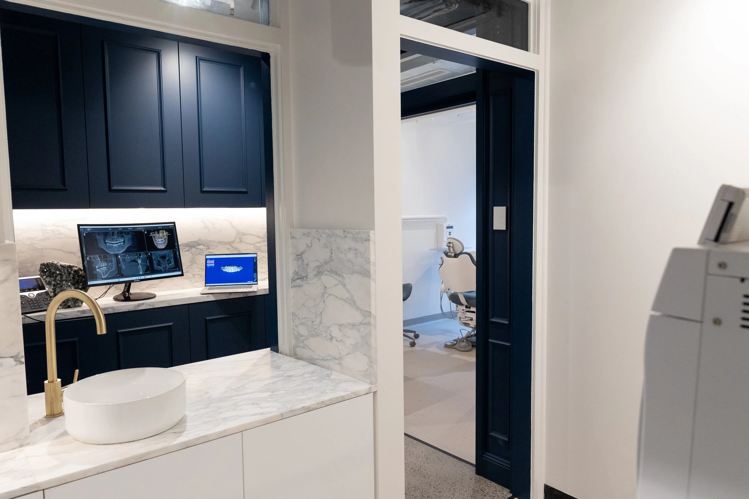 A modern dental clinic with stone benchtops and dark blue joinery
