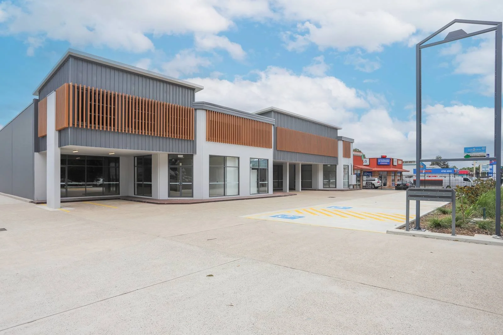 a modern indystrial building with dark grey and white walls and timber cladding