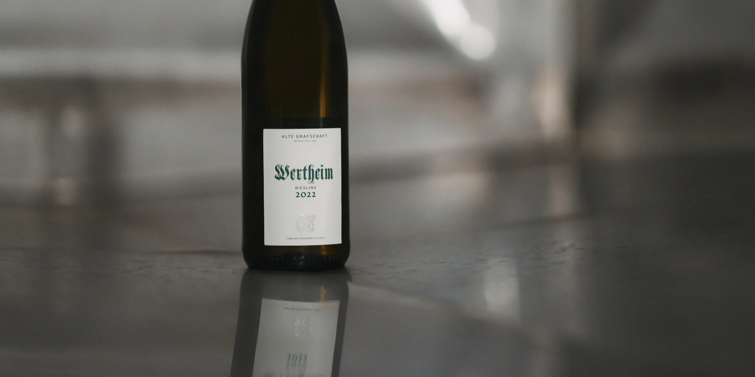 Eine Weinflasche mit weißem Etikett, auf dem steht: 'Wertheim Riesling 2022'.
