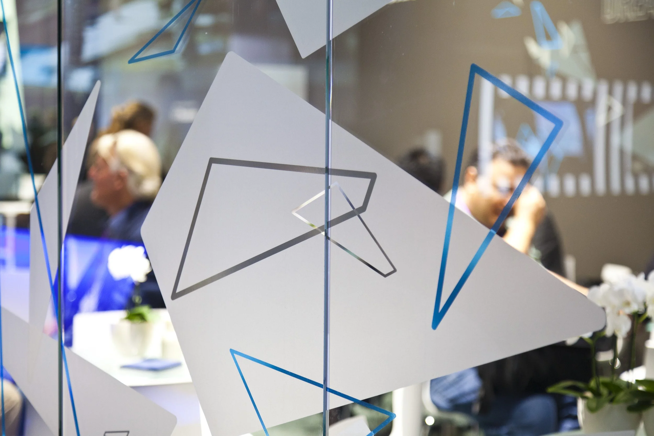 Detail der Panasonic Messegestaltung mit grafischen Dreieckselementen auf einer Glaswand als markenprägendes Designelement