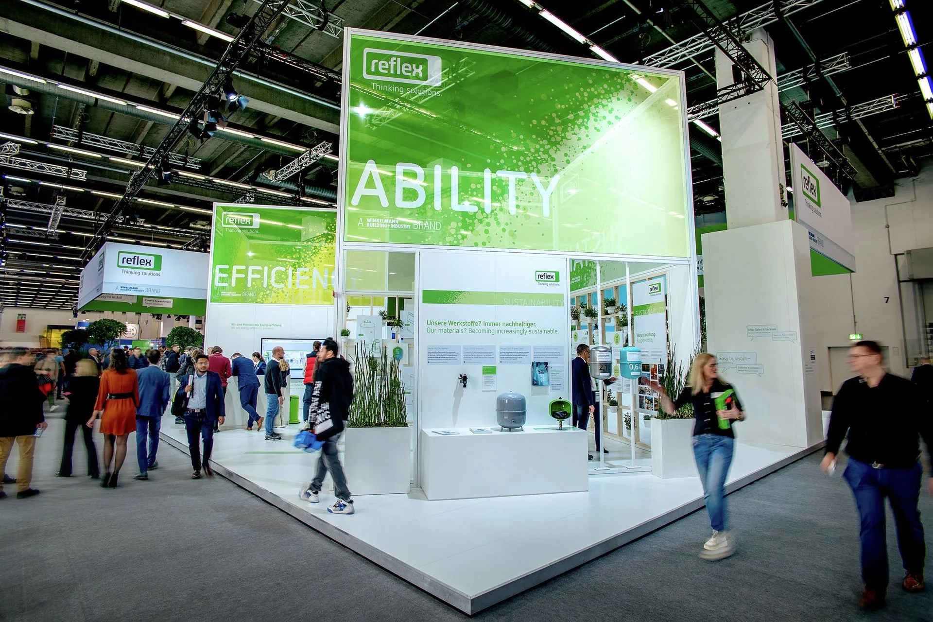 Großflächige, hoch angesetzte Banner wirken weit über den Messestand hinaus als Blickfang