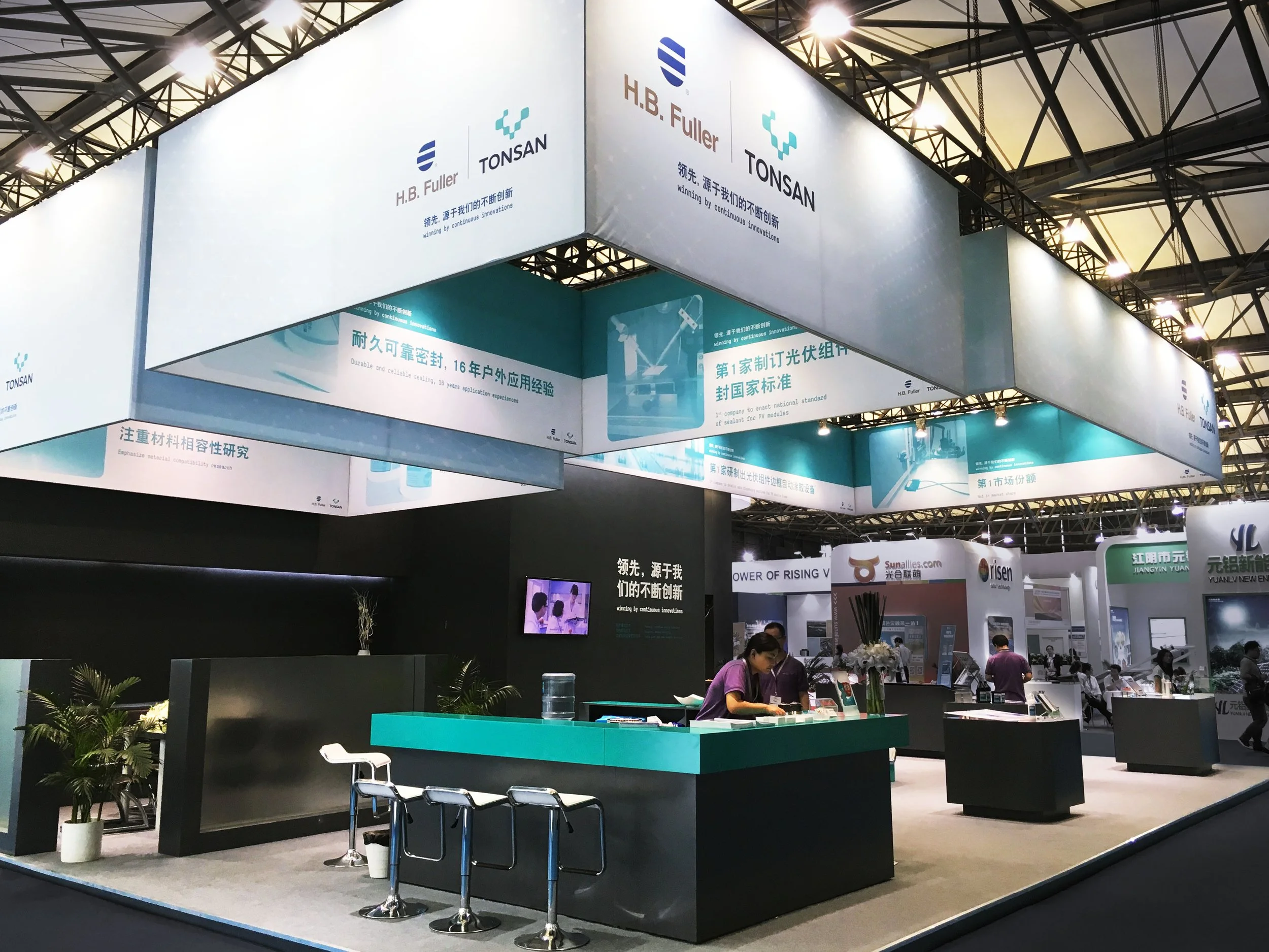Messestand von H.B. Fuller und Tonsan mit umlaufenden Markenbannern und Empfangstheke auf einer internationalen Fachmesse
