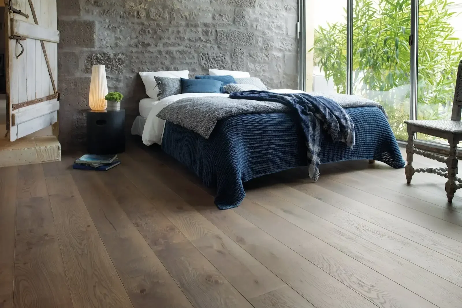 Warm oak wood flooring in a luxury master bedroom with modern decor.