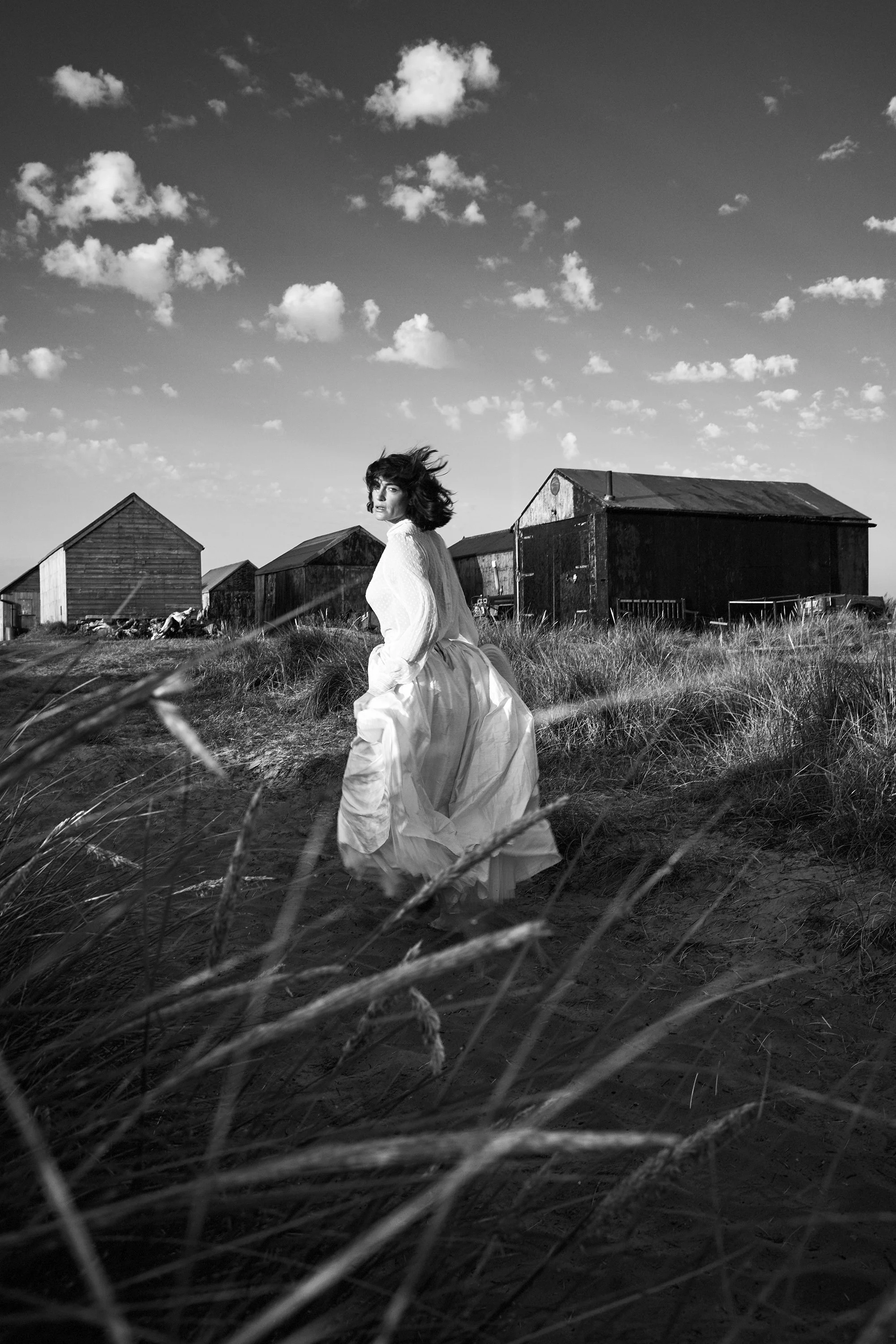 black and white model running down a lane against huts.jpg