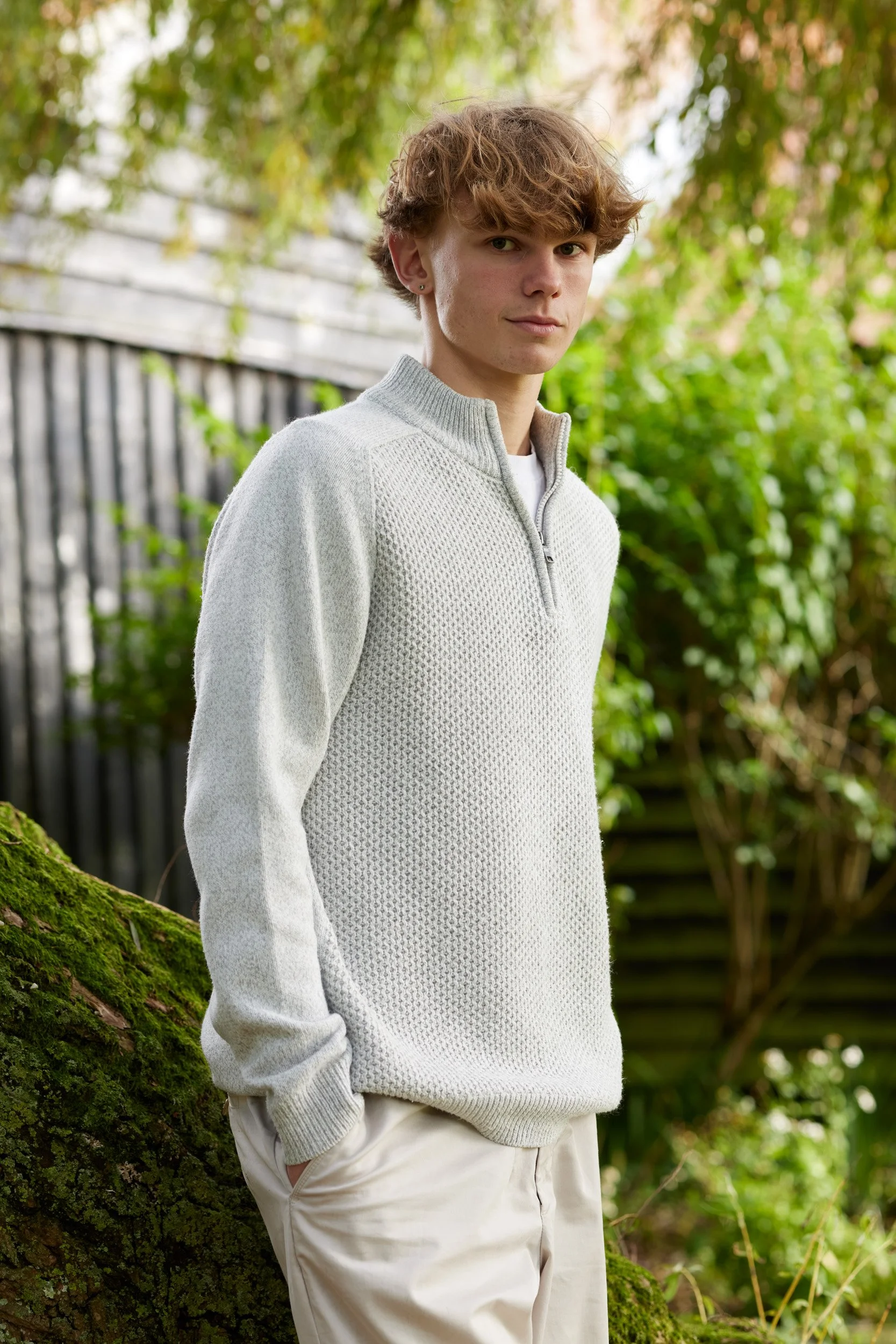 young_man_with_an_easy_smile_poses_in_a_garden.jpg