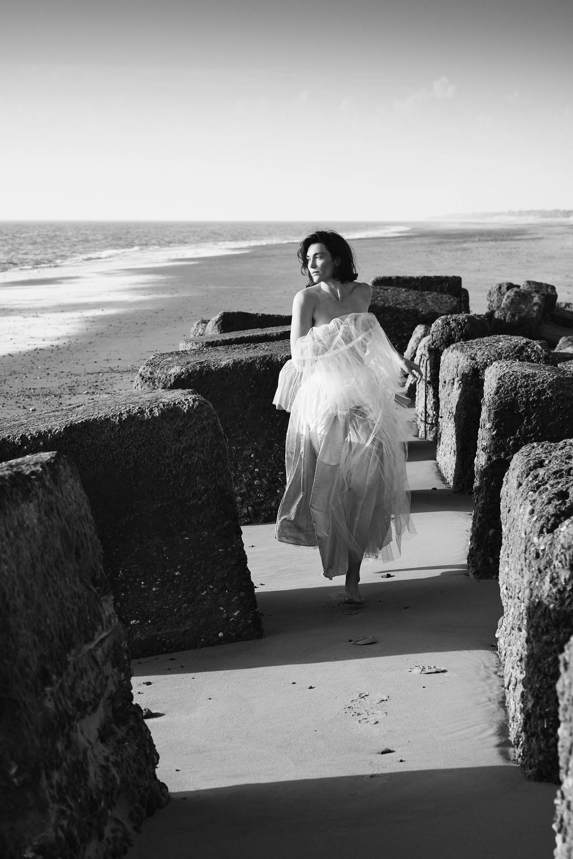 black and white model running across beach.jpg