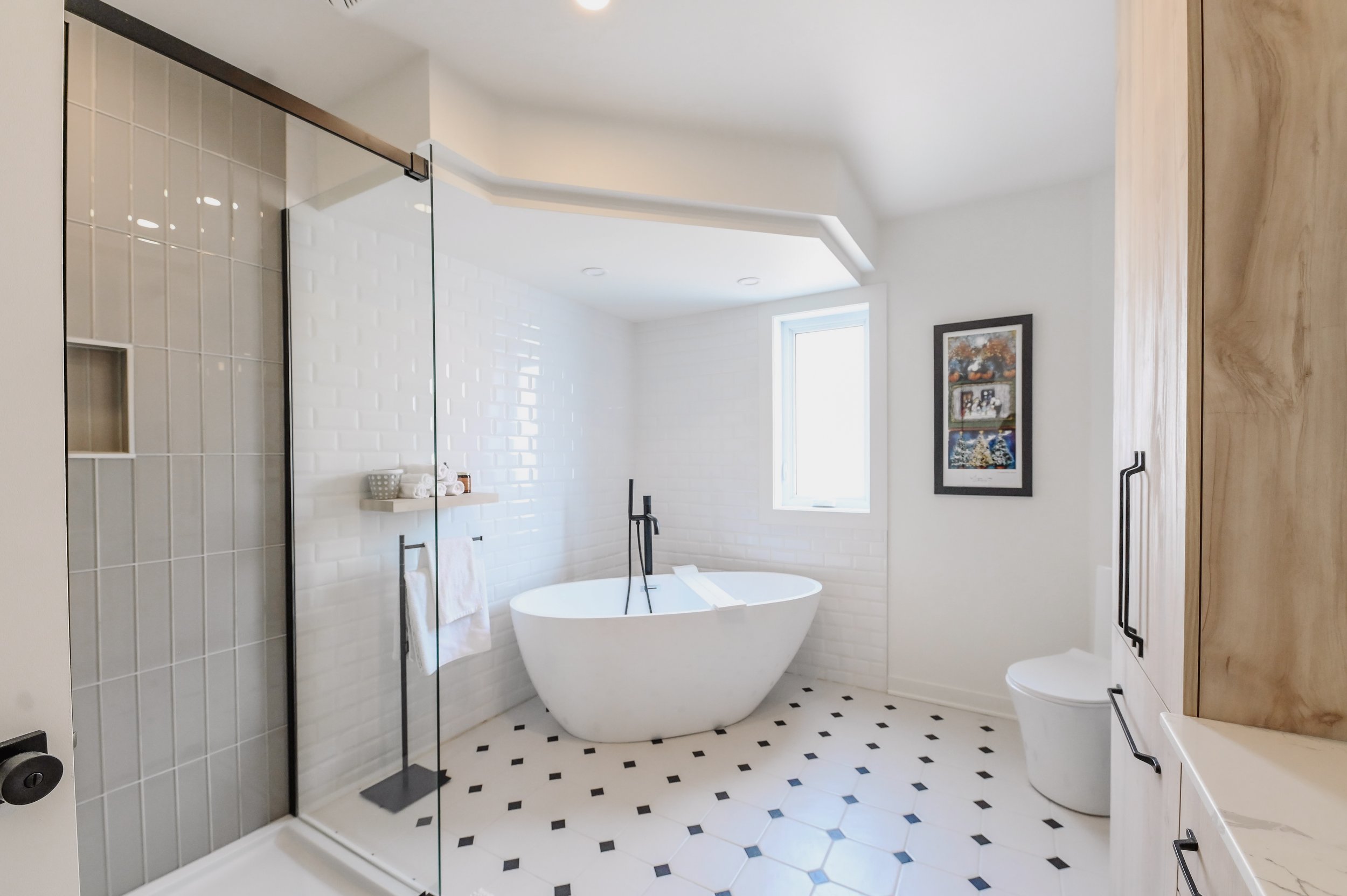 Classic New York style master ensuite with freestanding tub and black and white patterned tile floor, Montreal West