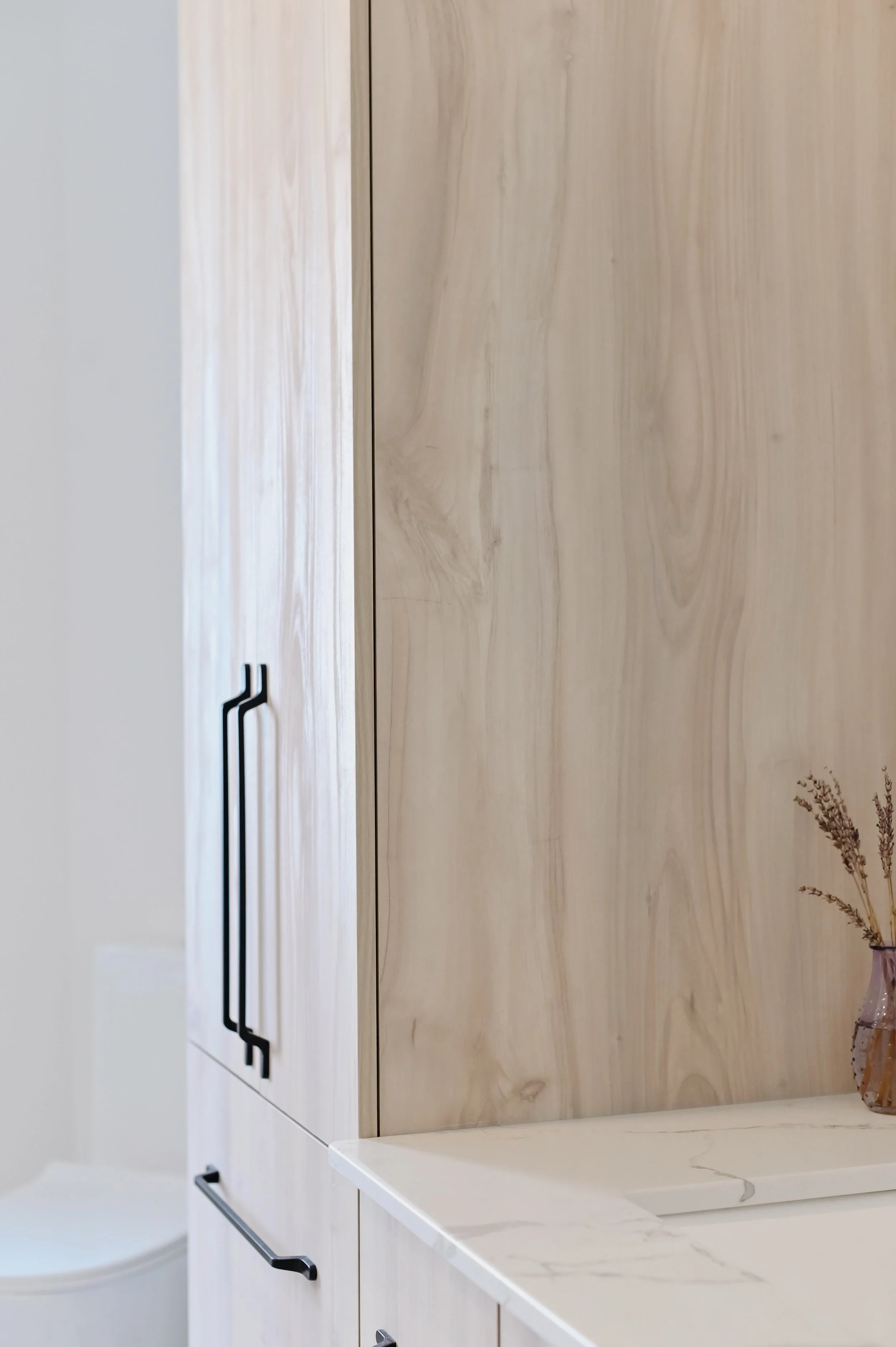 Custom wood vanity cabinet with black hardware, New York style ensuite