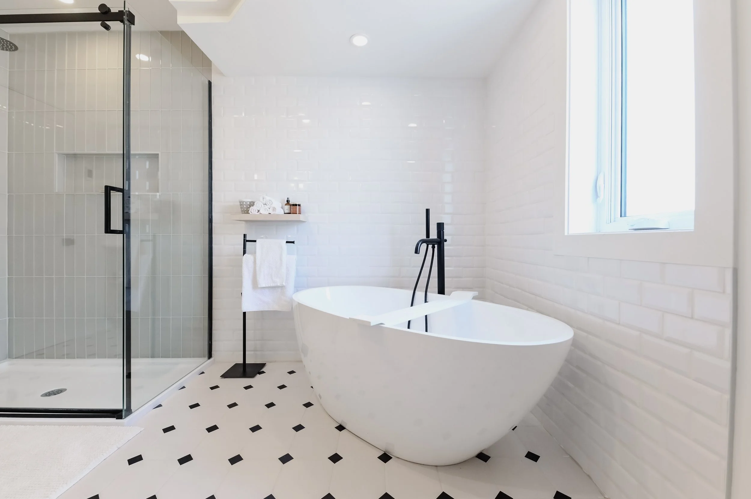 Classic New York style ensuite with freestanding tub and glass shower, black and white patterned tile, Montreal West