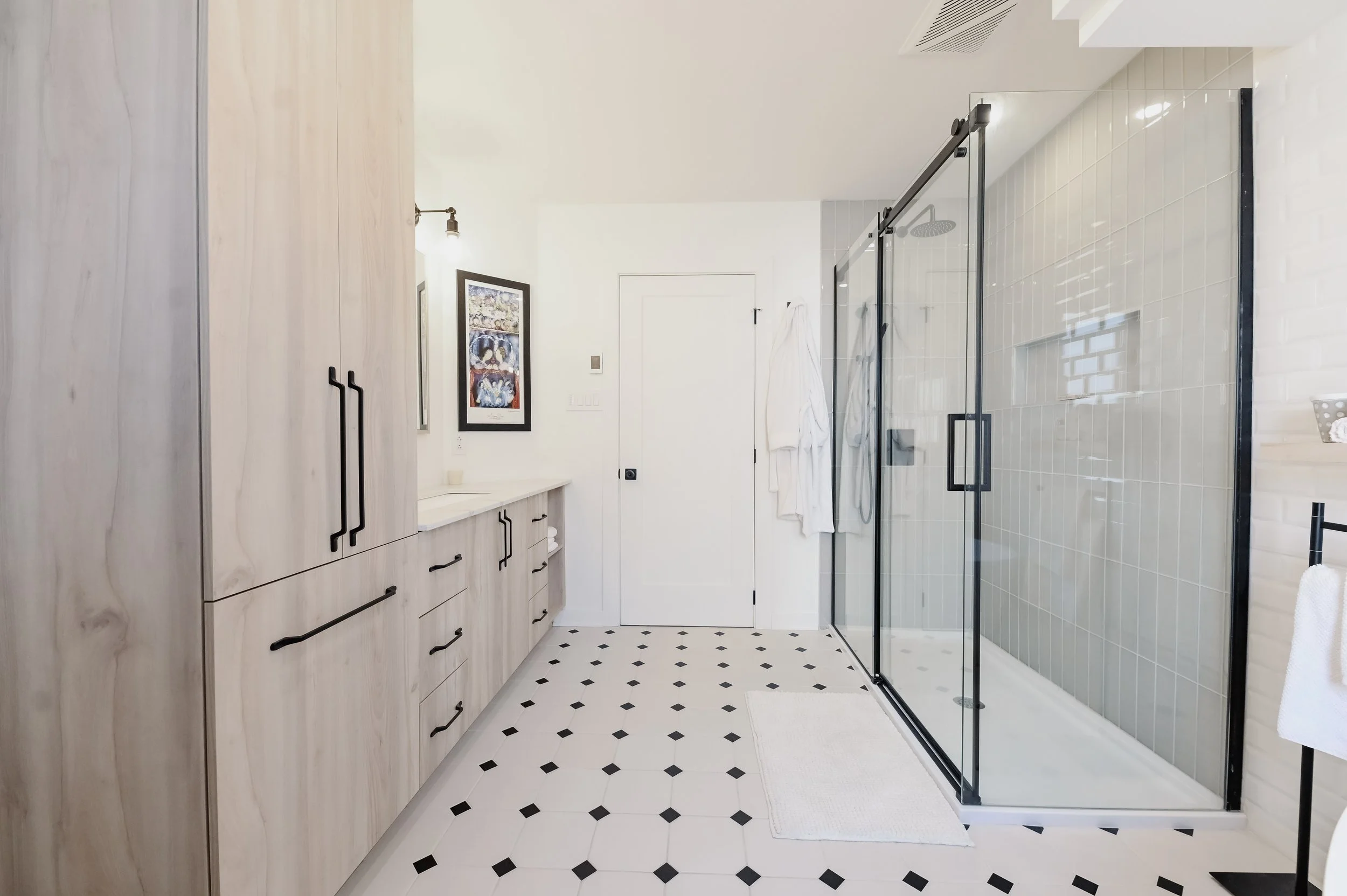 New York style bathroom hallway with white wood vanity, black hardware and glass shower, Montreal West