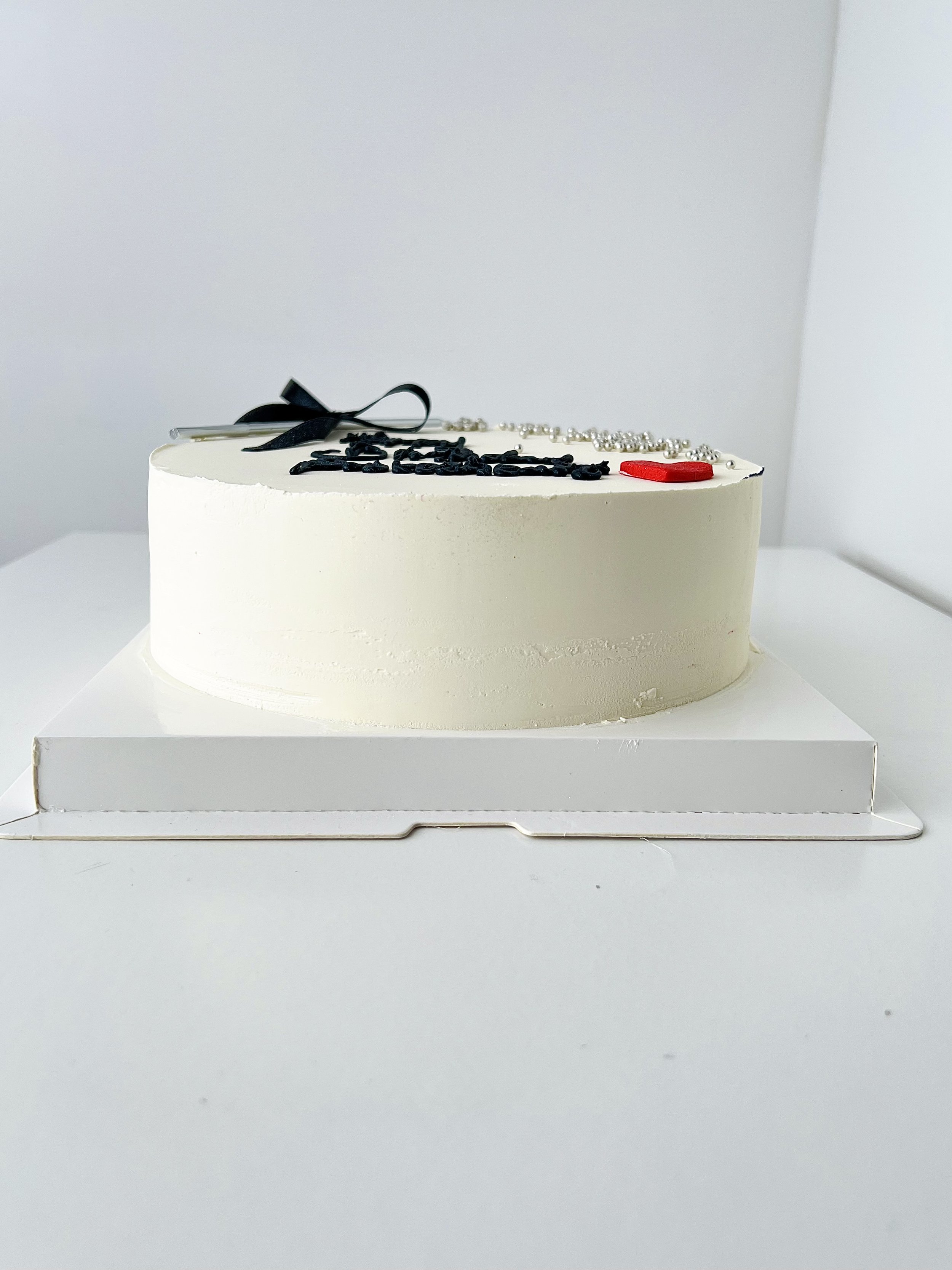 Single Layer White Cake with Pearls and Candle by Sensational Cakes and Desserts.