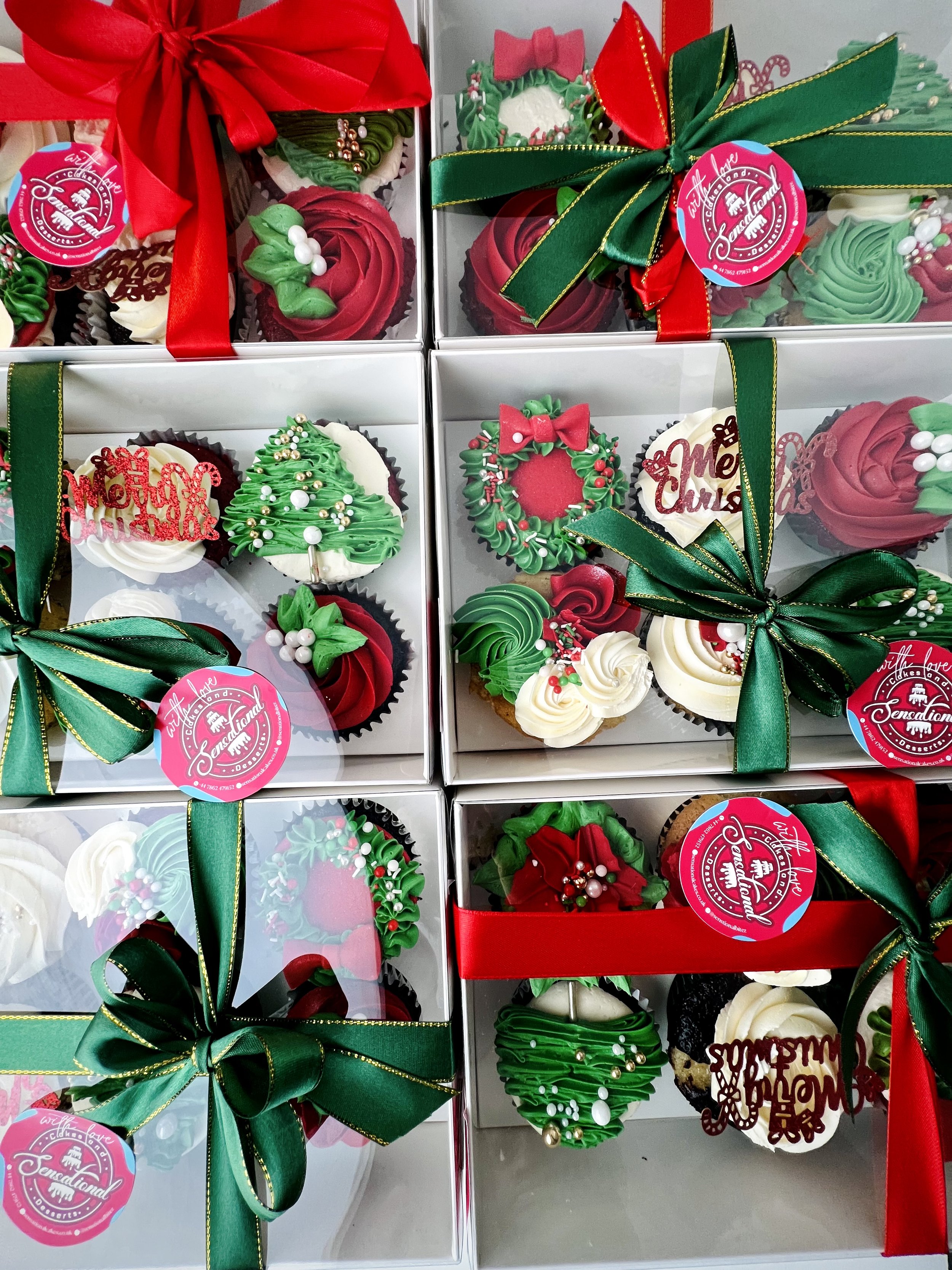 Boxes of Luxury Christmas Cupcakes by Sensational Cakes and Desserts, featuring an elegantly decorated box with red and green ribbon.