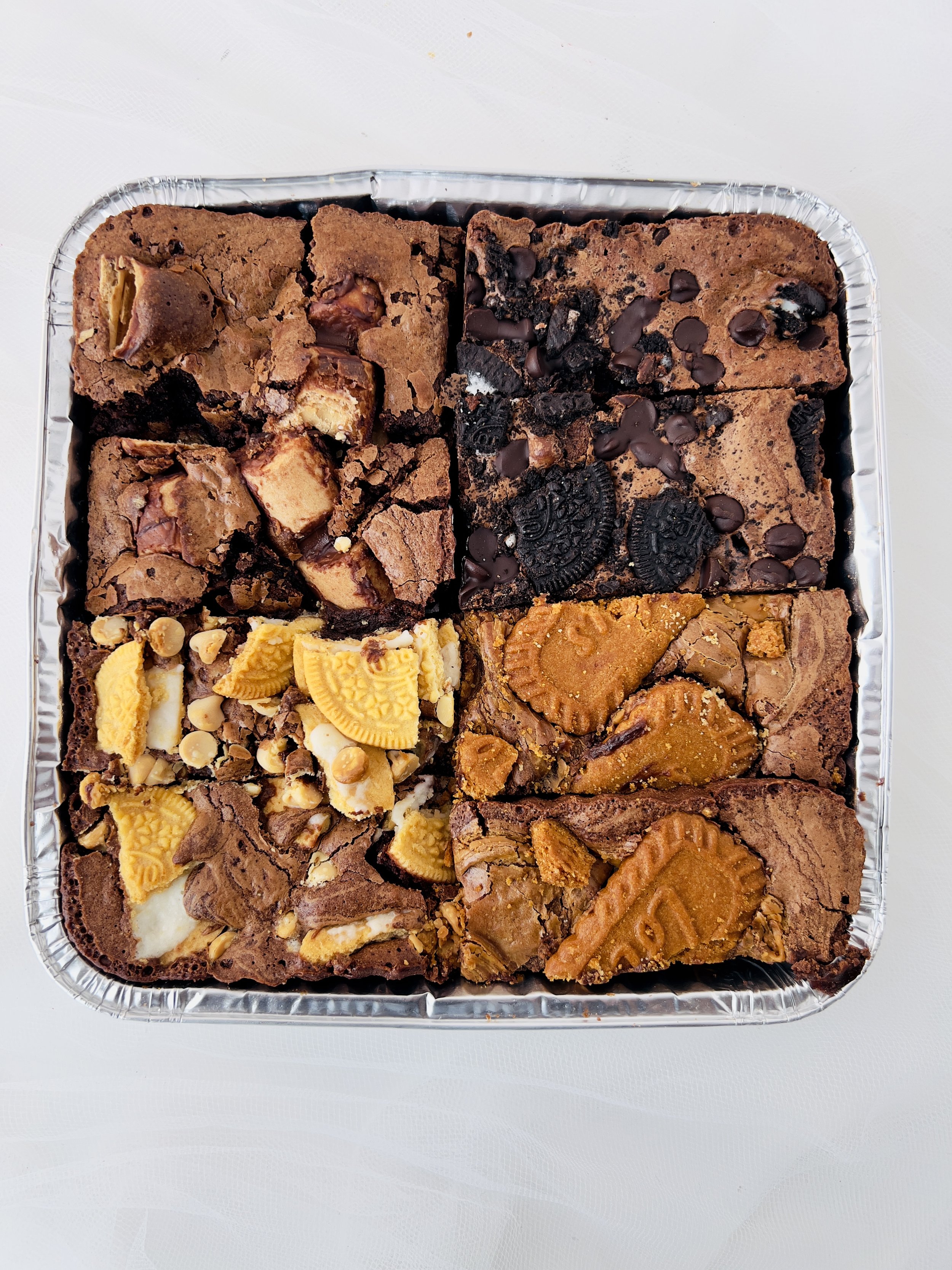 Brownie Selection Tray by Sensational Cakes and Desserts featuring Kinder Bueno Brownies, Oreo and Dark Chocolate Brownies, Golden Oreo with White Chocolate Brownies, and Lotus Biscoff Brownies.