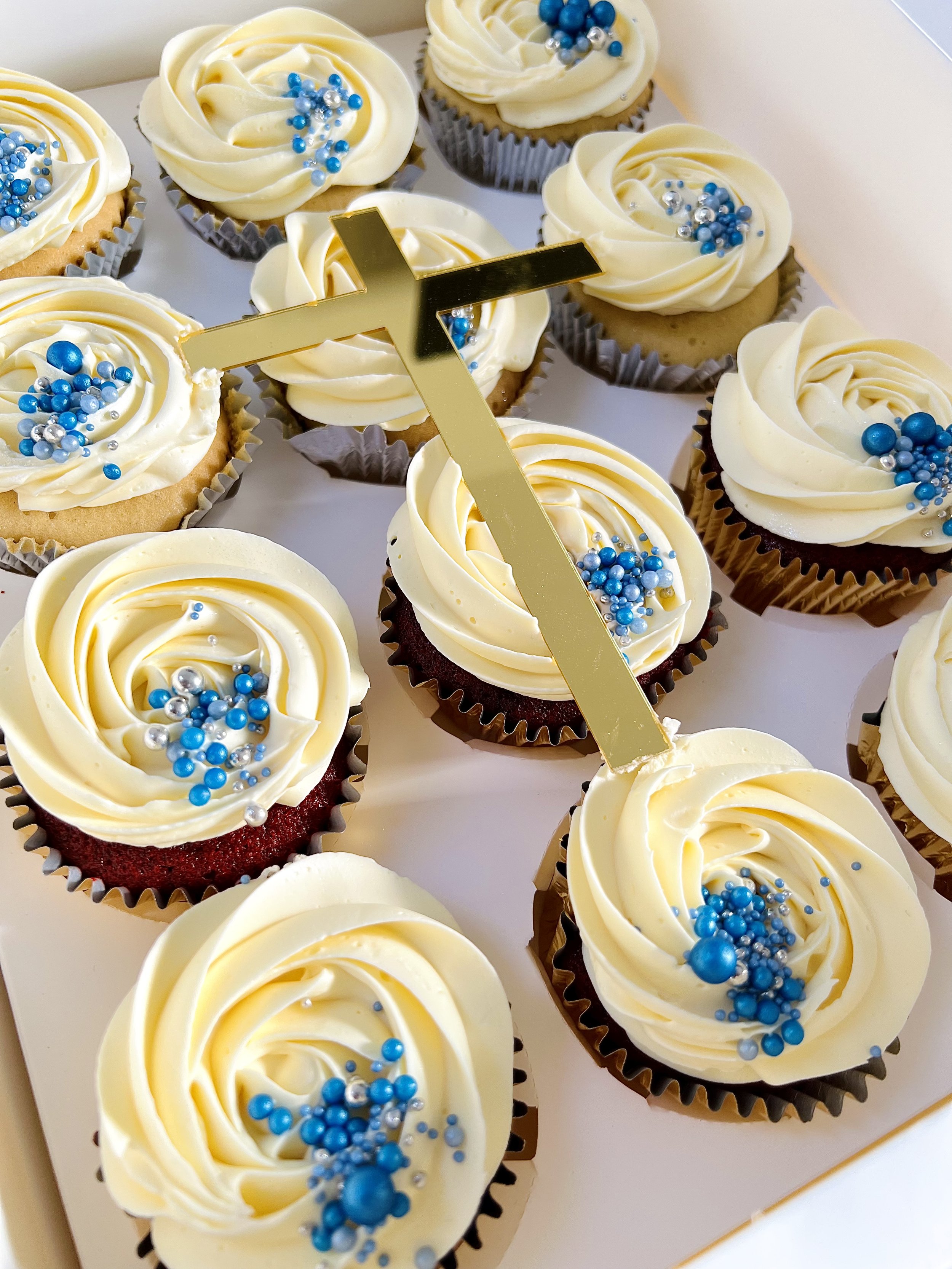 Christening Cupcakes with Acrylic Cross, smooth buttercream swirls and blue festive sprinkles.