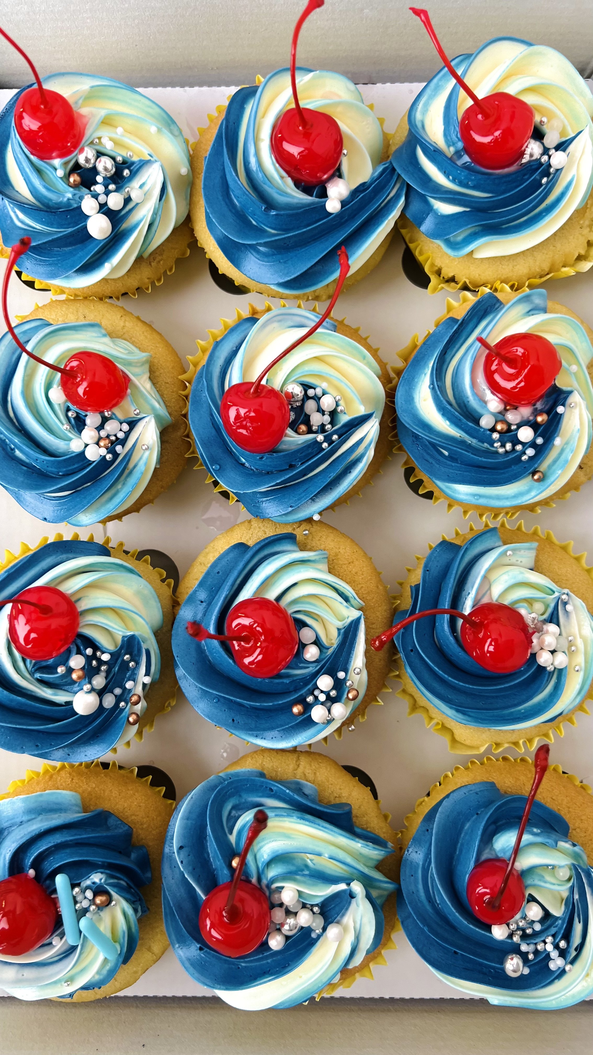 Cherry Topped Cupcakes with Shades of Blue Buttercream Piping by Sensational Cakes and Desserts.