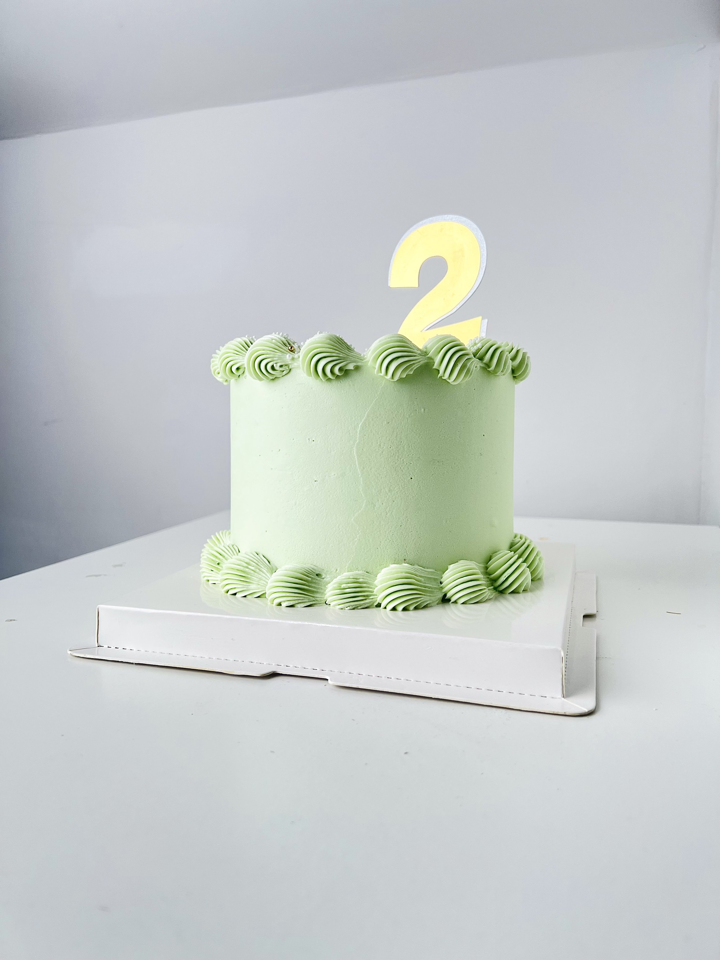 Side view of the Top view of the Elegant Green Birthday Cake With Gold Number Topper by Sensational Cakes and Desserts