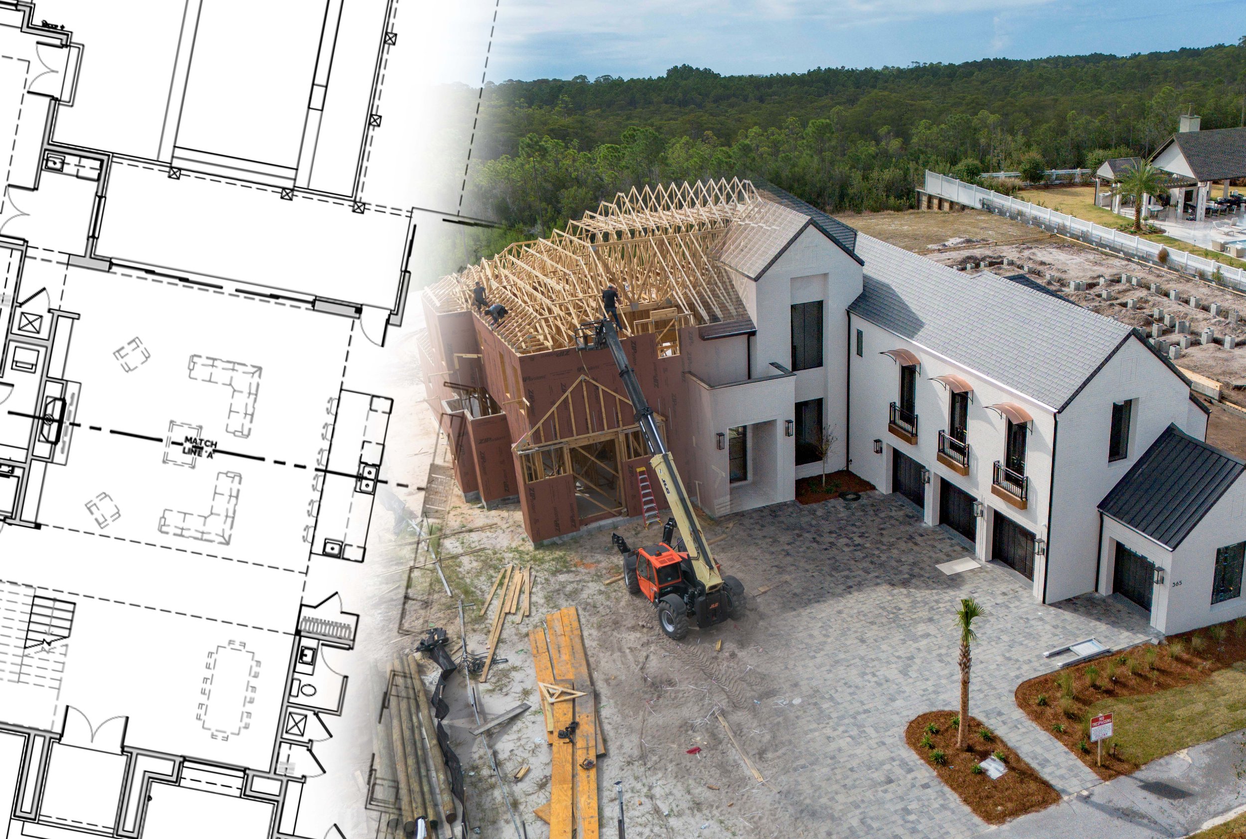 A house under construction with wooden framing on the roof and a crane lifting building materials, alongside a finished white house with a tiled roof and small balconies, set in a developing neighborhood with some landscaping and other houses in the background.