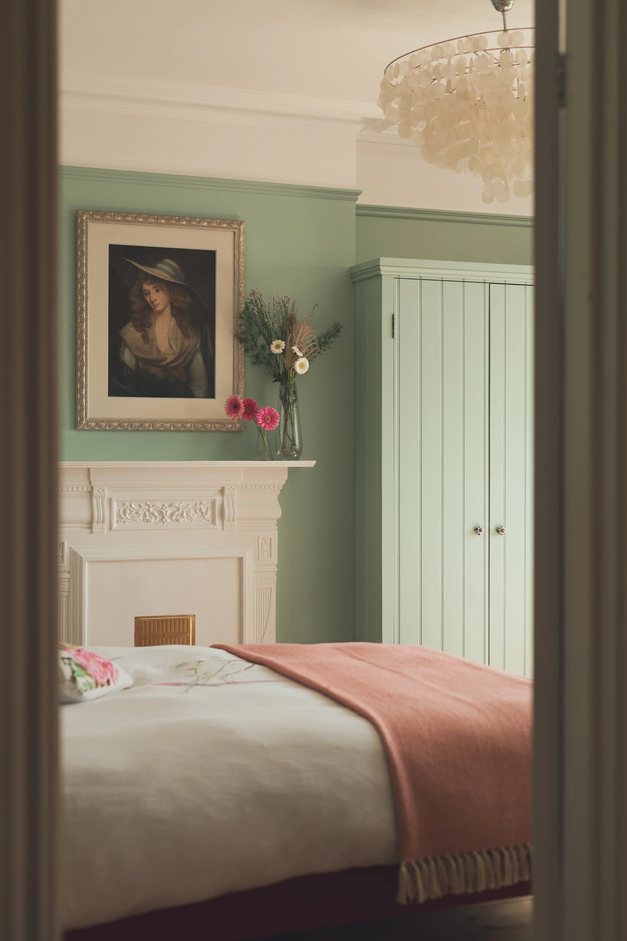 Doorway view into blue bedroom with wardrobe and chandelier.jpg