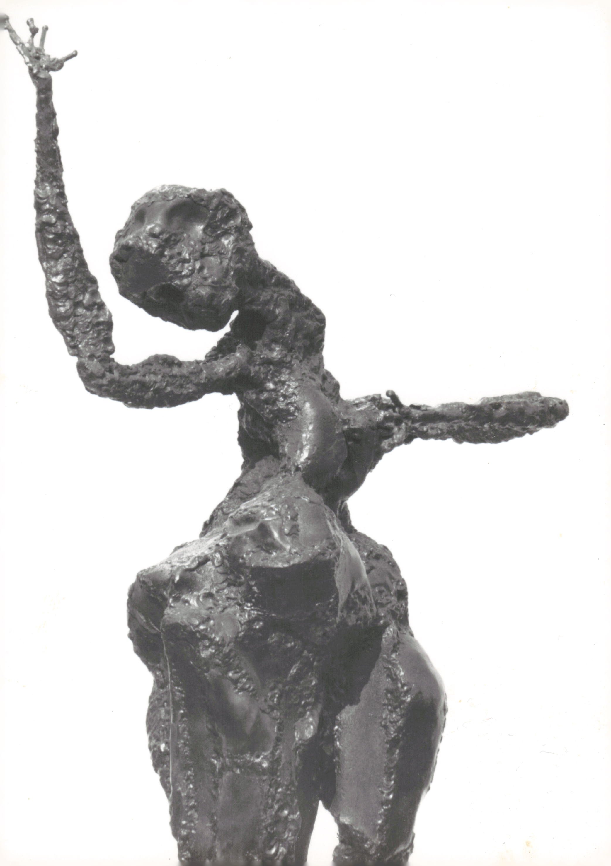A sculpture of a person in a yoga pose with one arm raised, made of a rough, textured material, mounted on a base against a plain background.