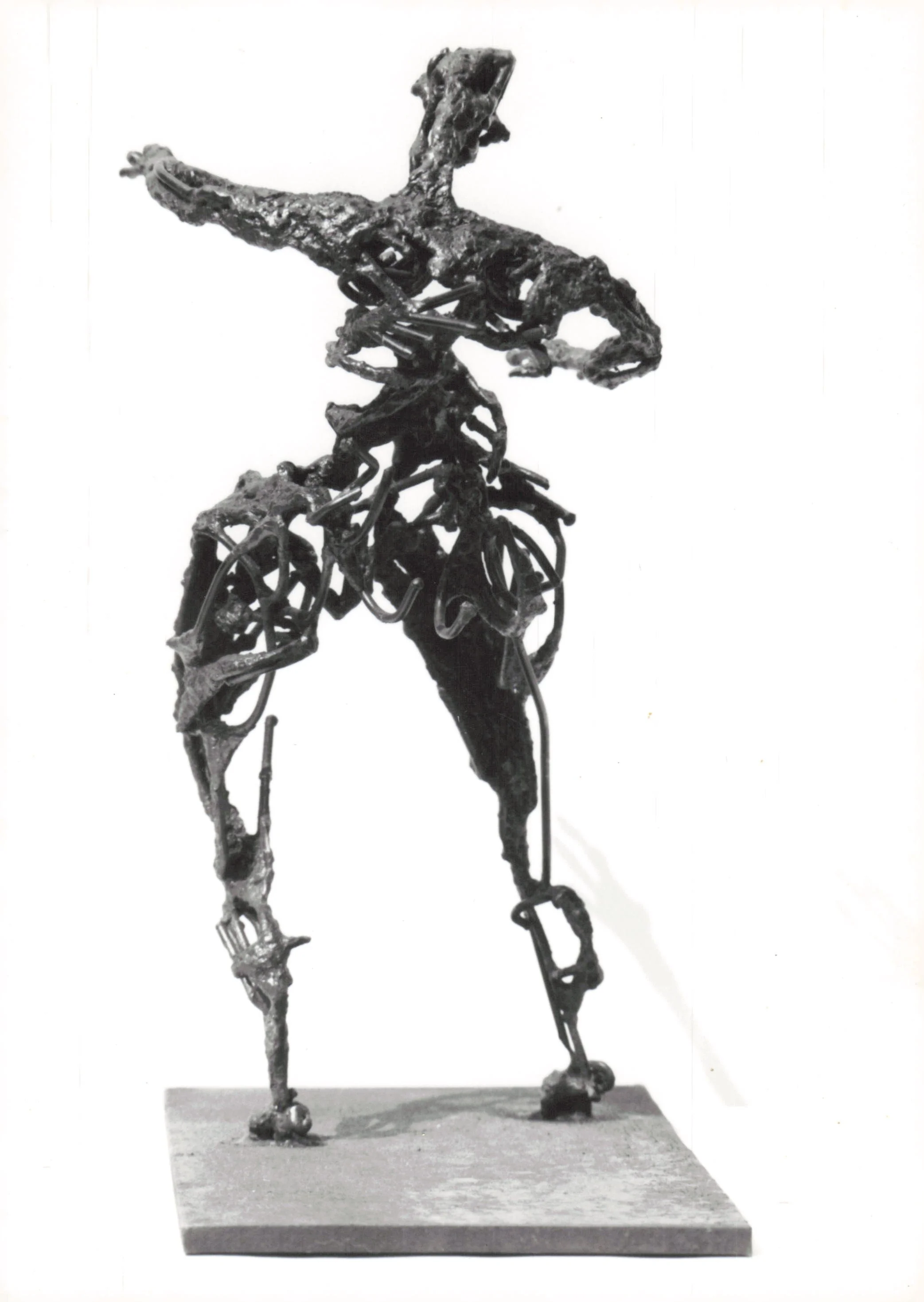 Abstract sculpture of a horse made from metal rods and other metal pieces, mounted on a rectangular base.