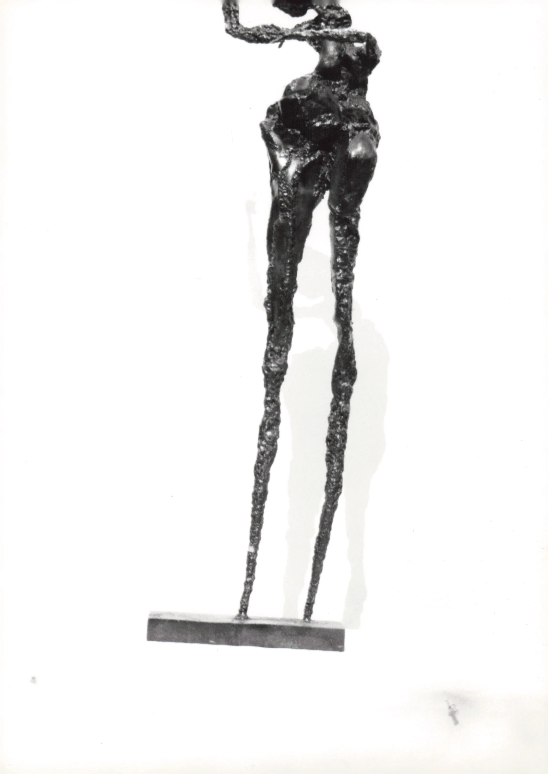 A black metal sculpture of a giraffe standing on a rectangular base.