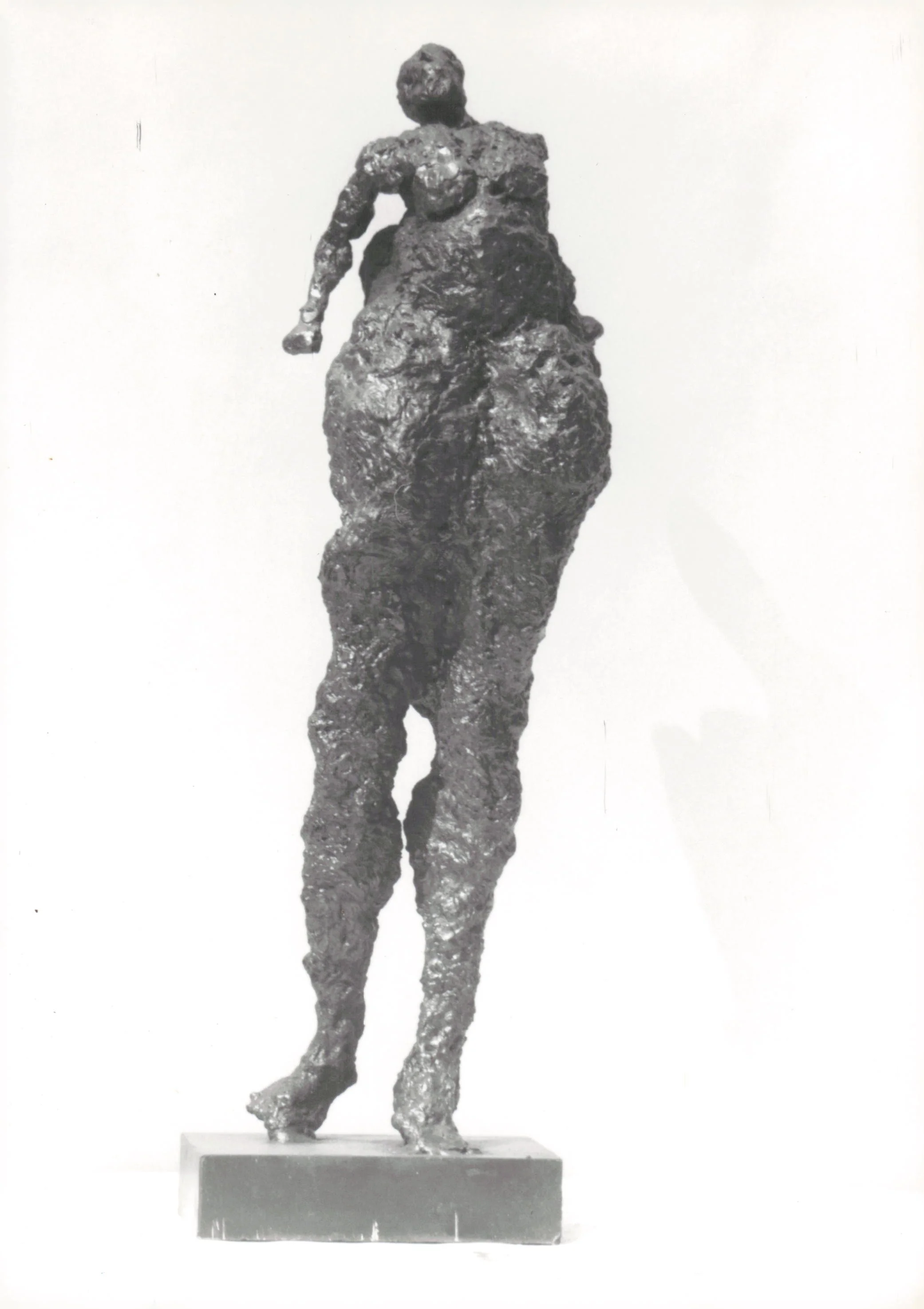 A sculpture of a woman with a textured, abstract surface, standing on a rectangular base.