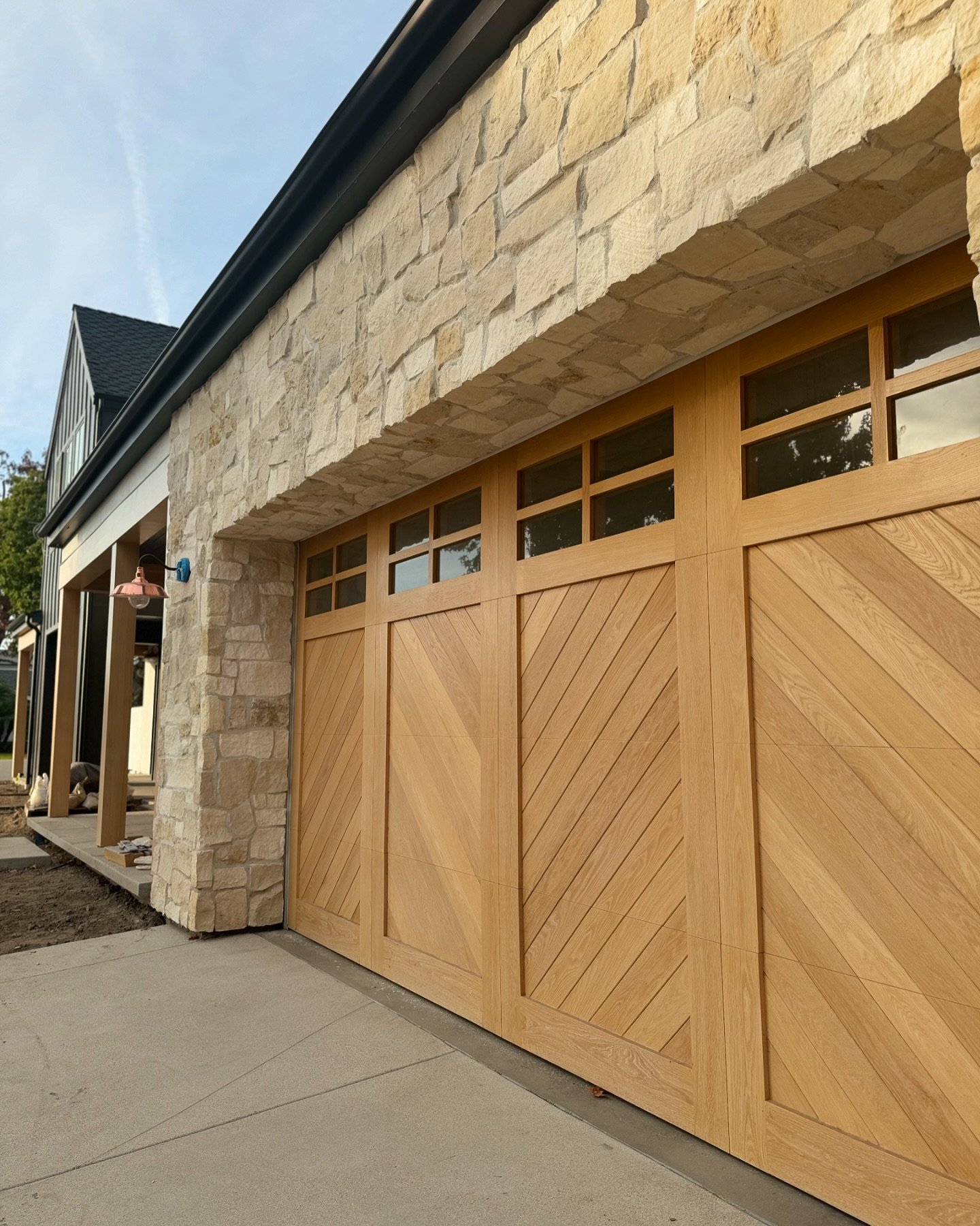Adding visual interest with this custom herringbone wood garage door. The warm wood tones and unique pattern perfectly complement the stonework and add character to the home&rsquo;s exterior design. 

#CustomHome #customhome #GarageDesign #OCBuilder