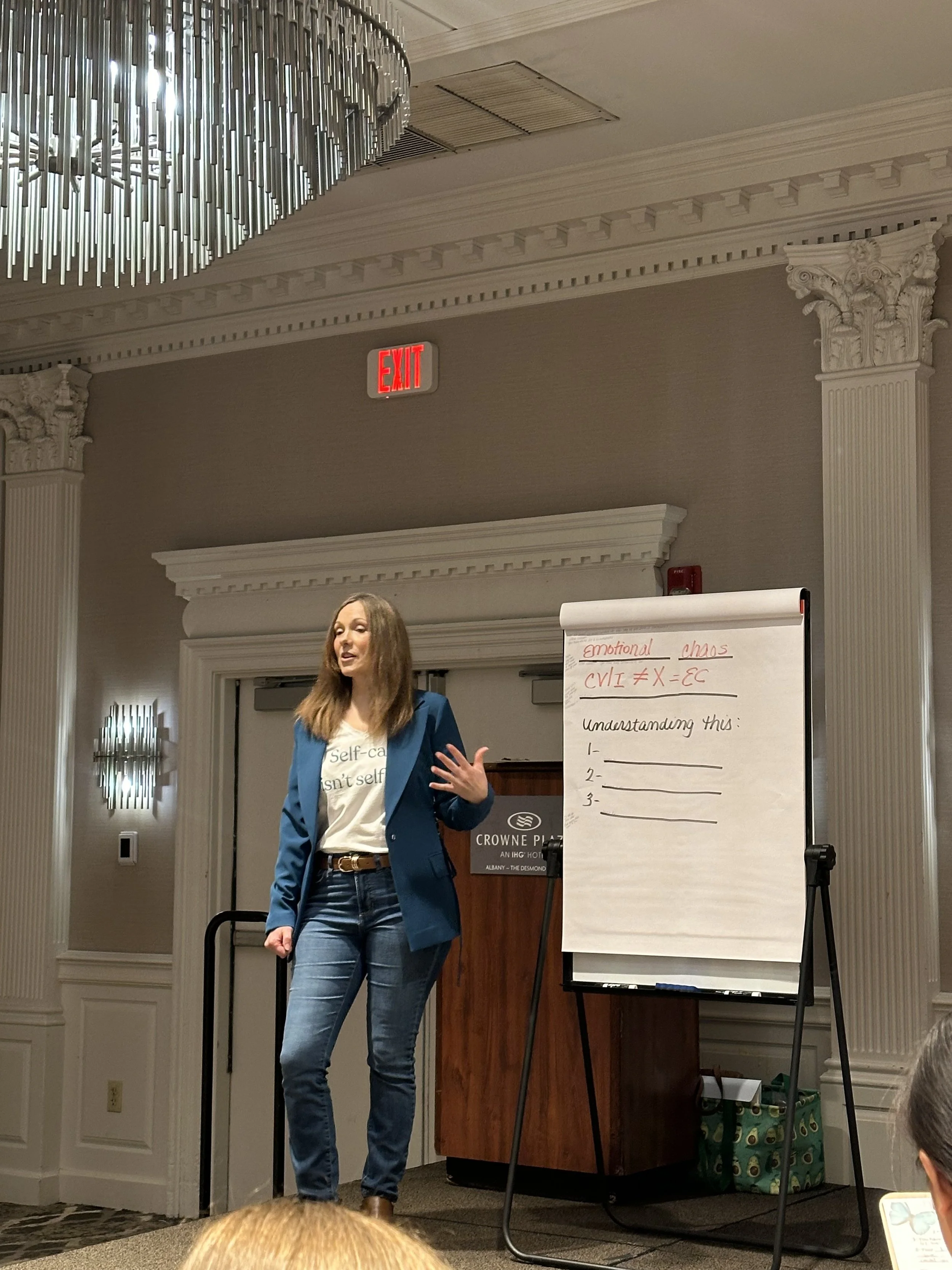 Jen speaking at the Getting Unstuck Workshop on stage with a flip chart.