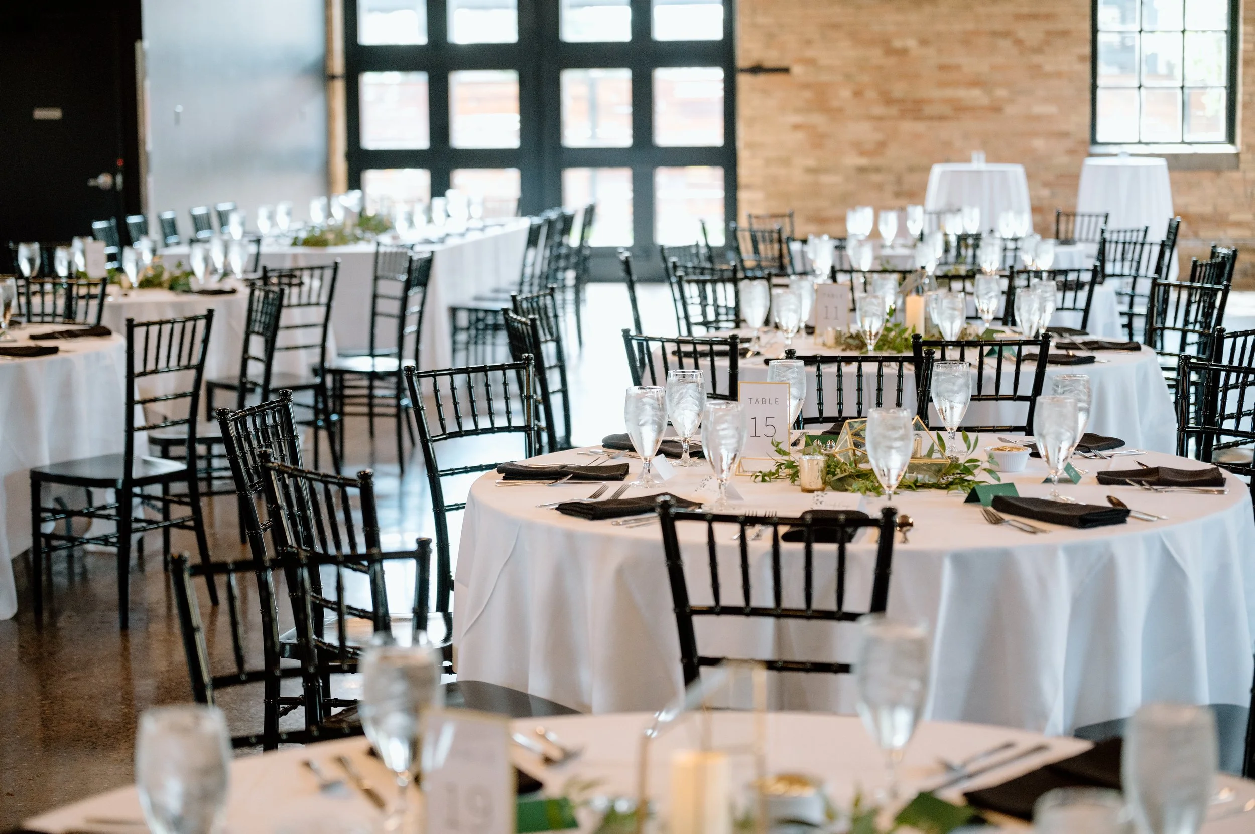 Greenery and golden candles wedding reception tablescapes at the Essence Event Center in St. Paul, Minnesota