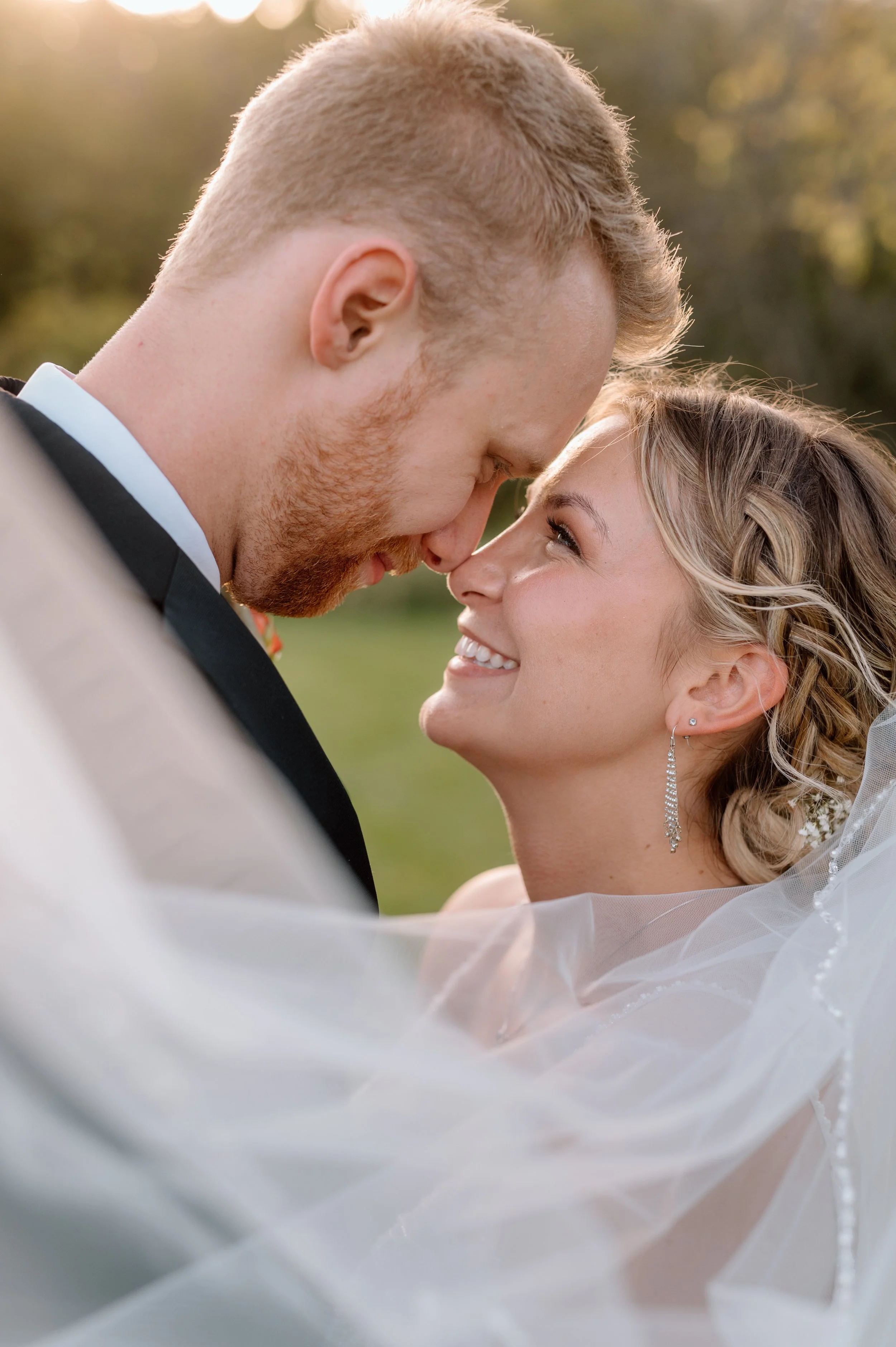 Bride and groom veil shot at sunset at the Falls wedding venue in St. Croix Falls