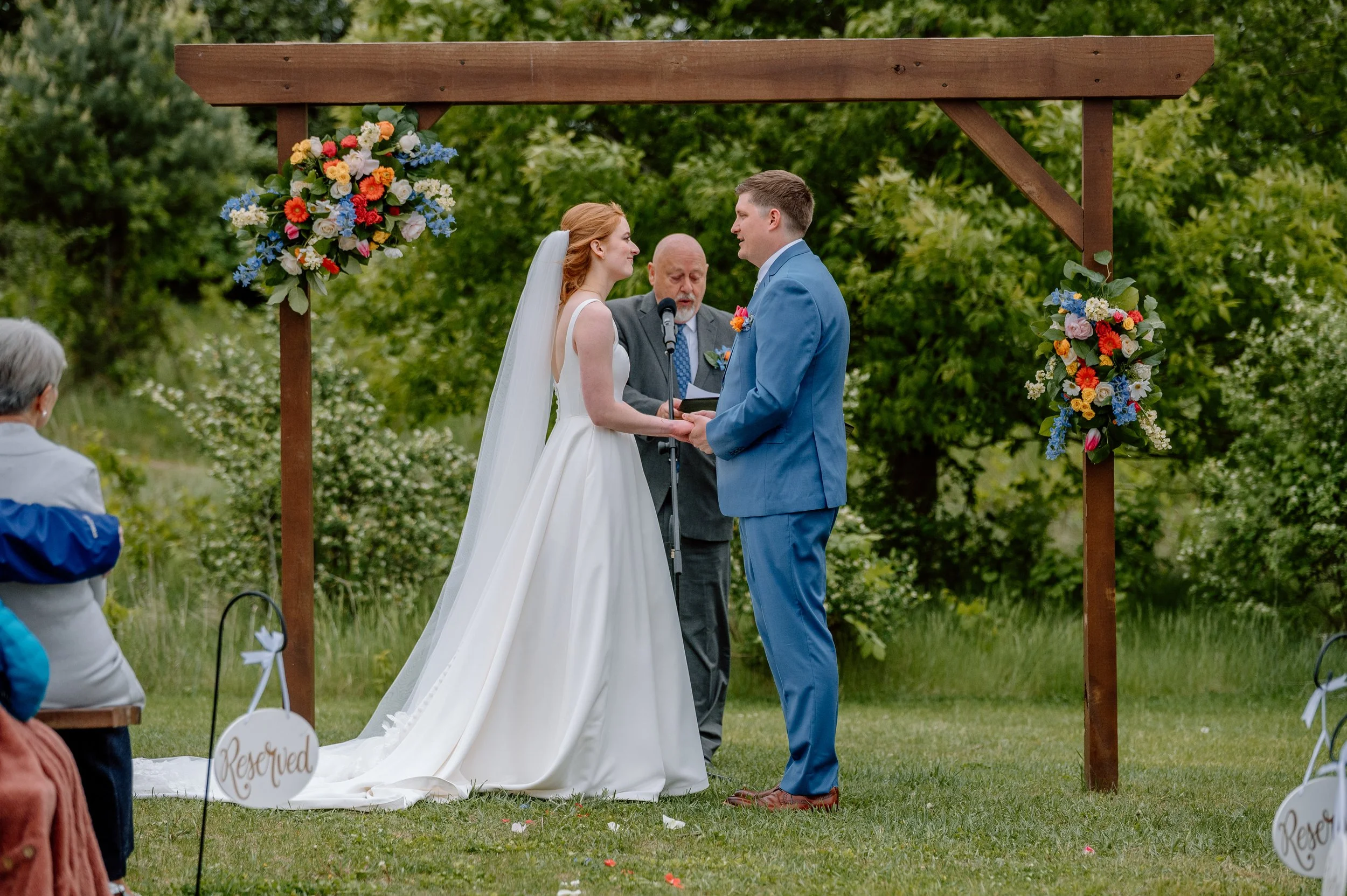 Bride and groom exchange vows in the meadow ceremony space at Genesis Ranch in Minnesota