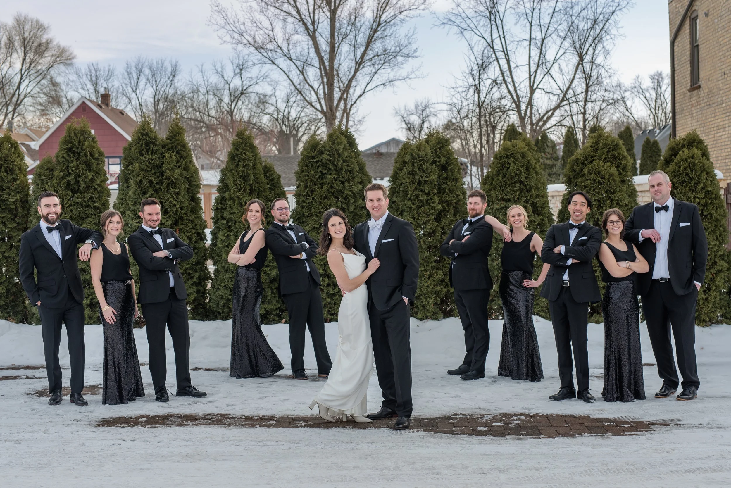 Wedding party in classic black and white pose outside for winter photos on a New Year's Eve wedding at The Broz in New Prague, MN