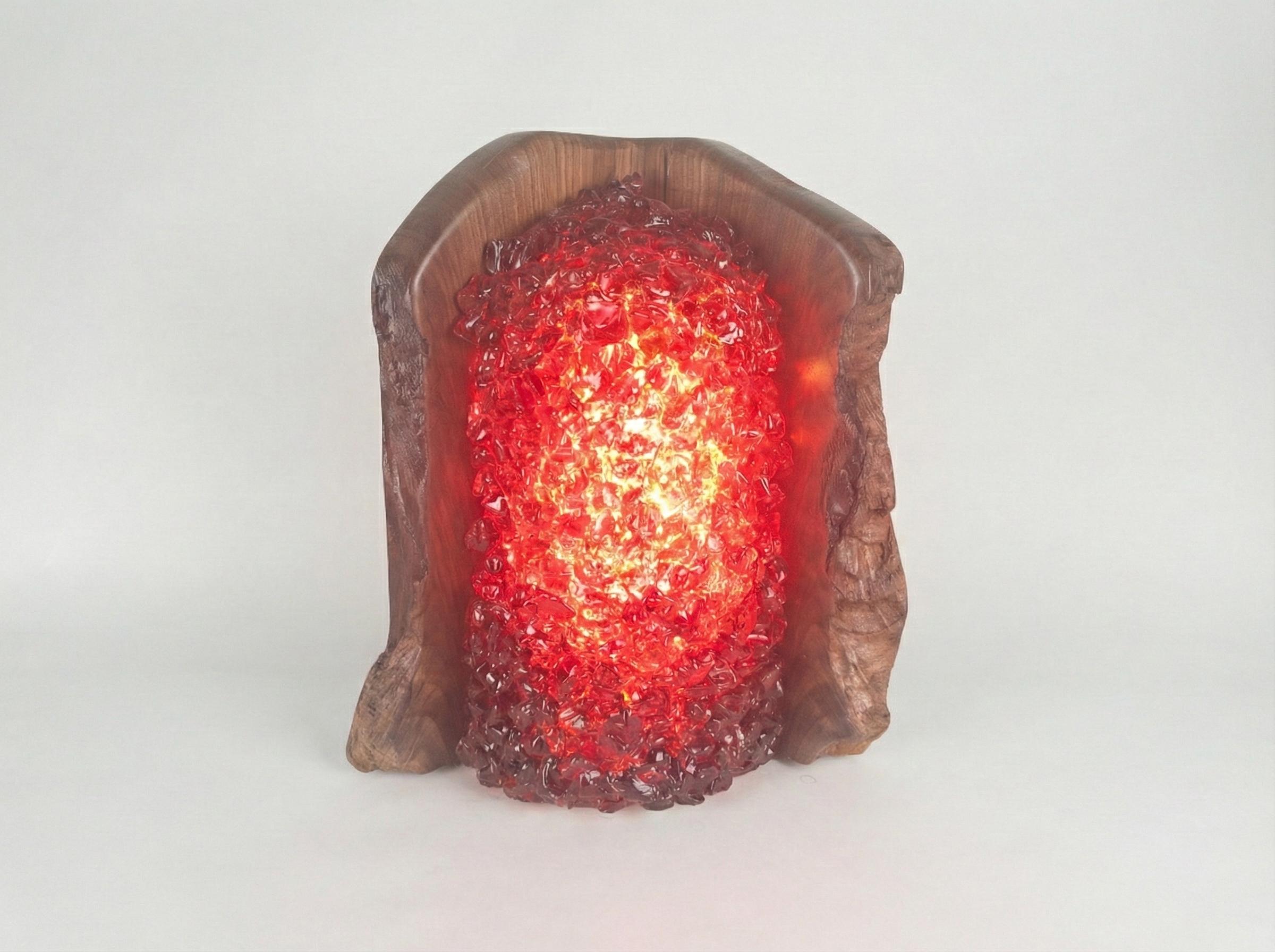 A lamp made of walnut wood with red glass surrounding the bulb