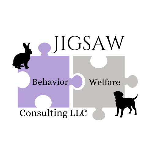 A purple puzzle piece containing the word "behavior" and a grey puzzle piece containing the word "welfare" connected together. Jigsaw rests above them and Consulting LLC rests below them. Graphics of a rabbit and dog sit at opposite corners.