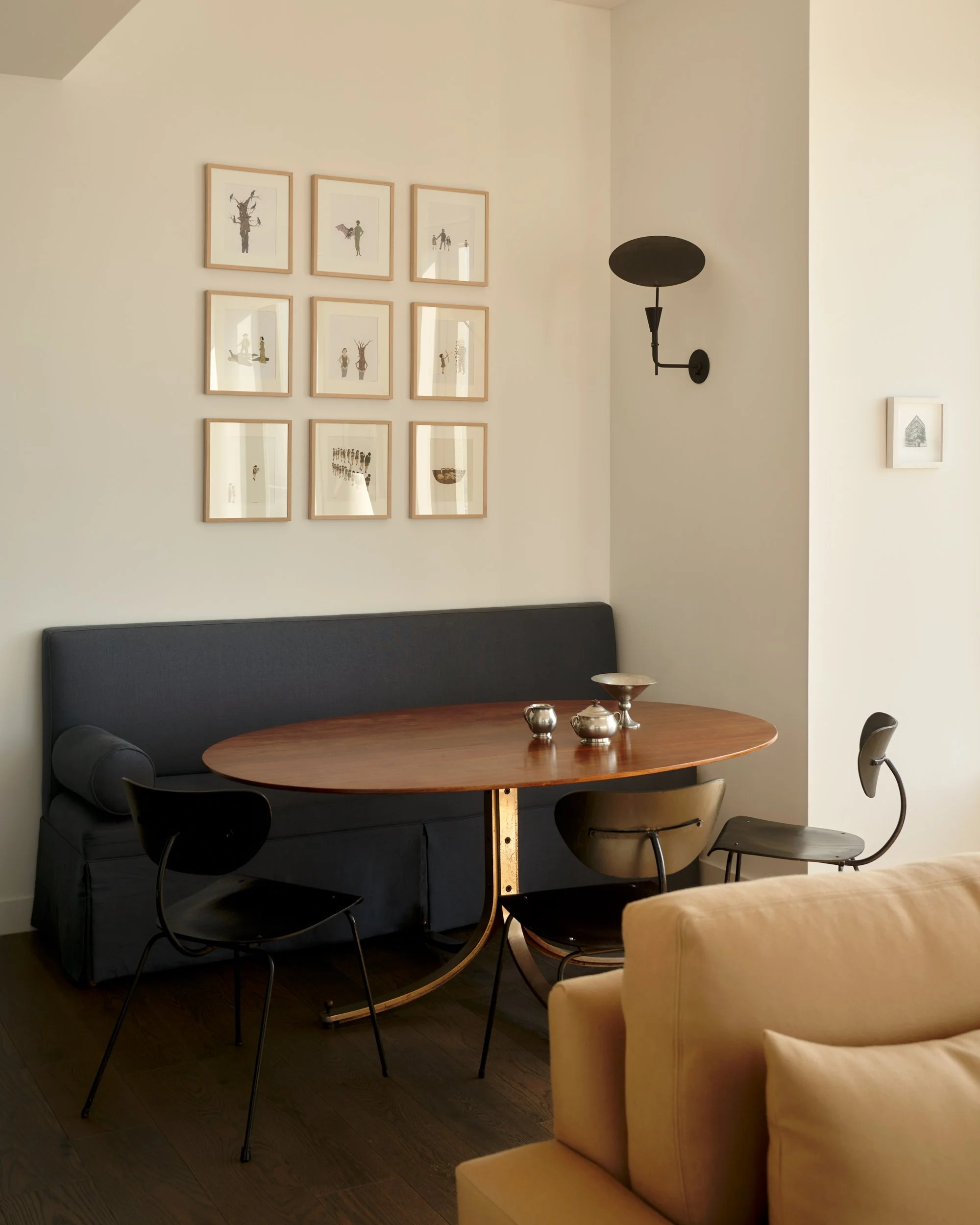 Vintage dining chairs surround a Sergio Mazza dining table and custom banquet. The sconce in by Allied Maker. Interior Design by Gennett Studio.